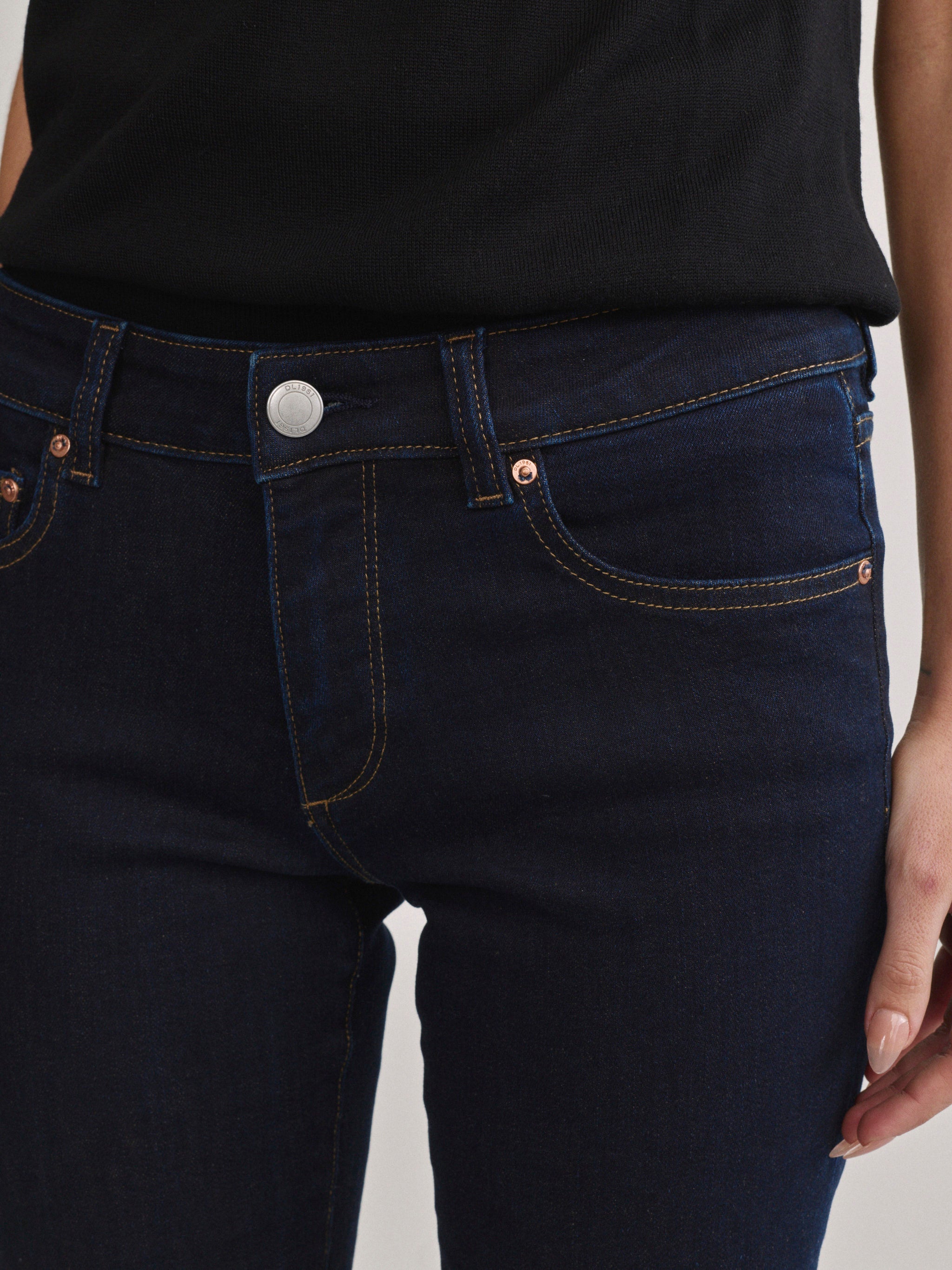 DL1961 Jessica Skinny low-rise jeans in dark indigo 'Harvest Moon', front waistband and rivet close-up.