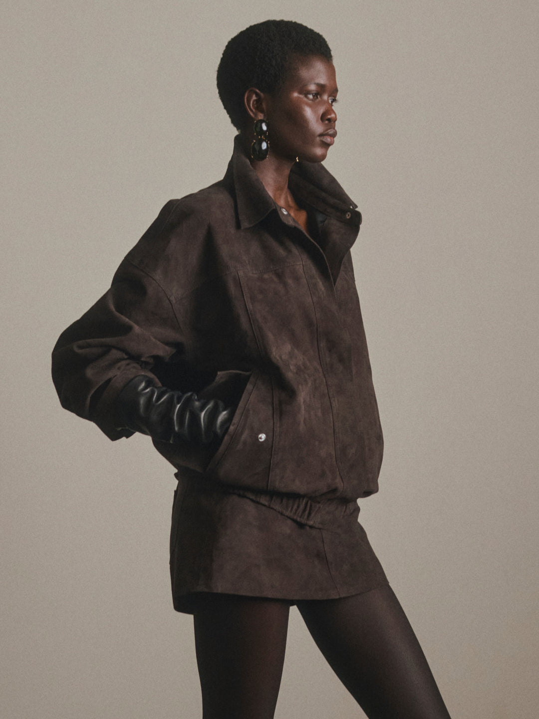 DL1961 Avalon Mini Low-Rise Suede Skirt in brown Tobacco Suede, full-length front with suede jacket and gloves.