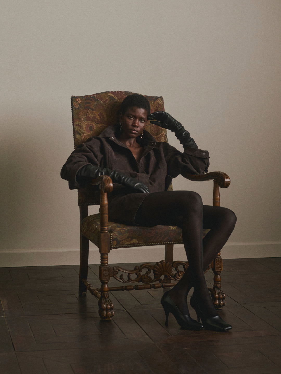 DL1961 Nara Oversized Suede Jacket in tobacco brown suede, oversized bomber, model seated in armchair.