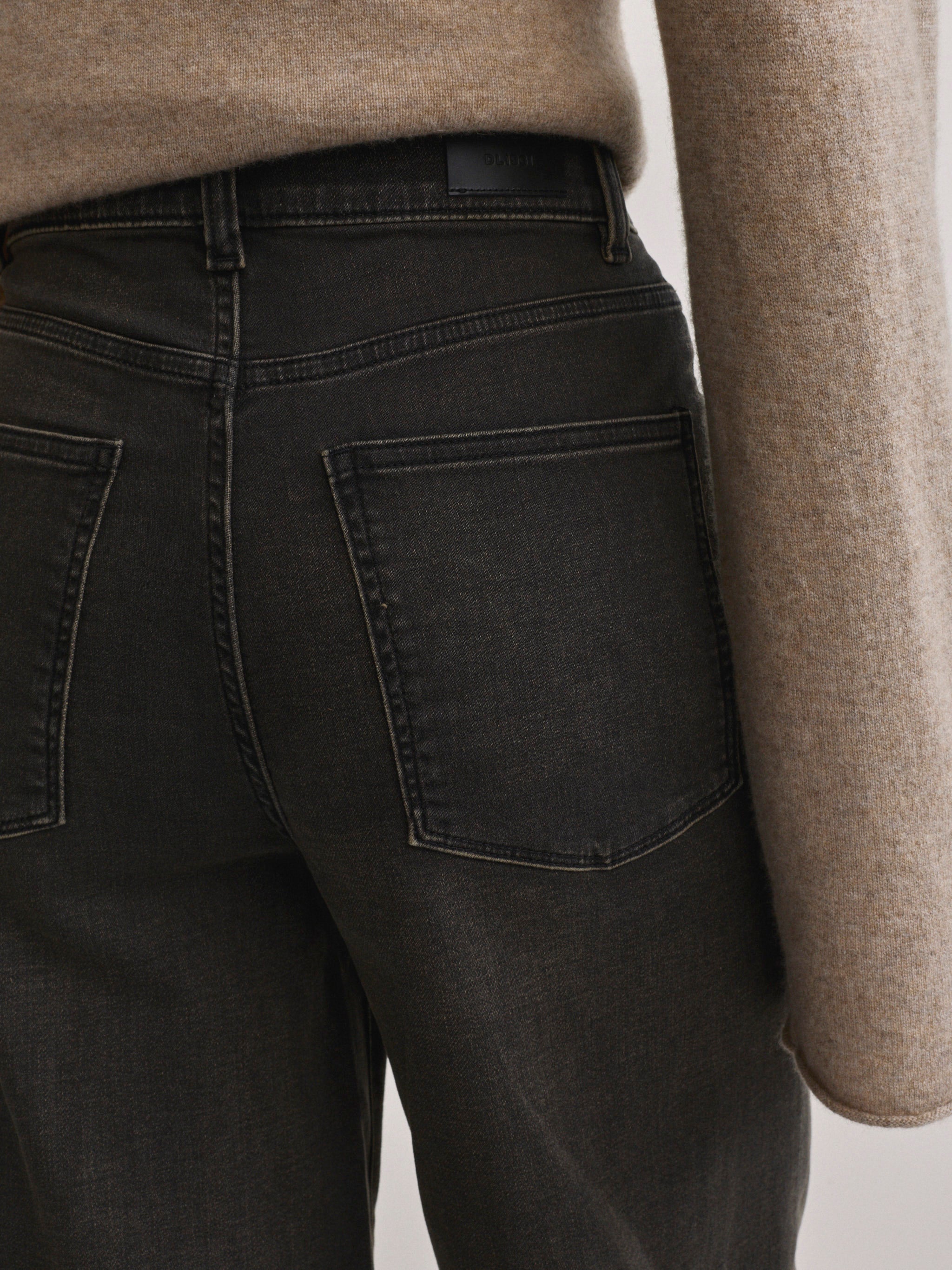 DL1961 Hepburn wide-leg high-rise jeans in washed black 'Rock', close-up of back pocket and waistband.