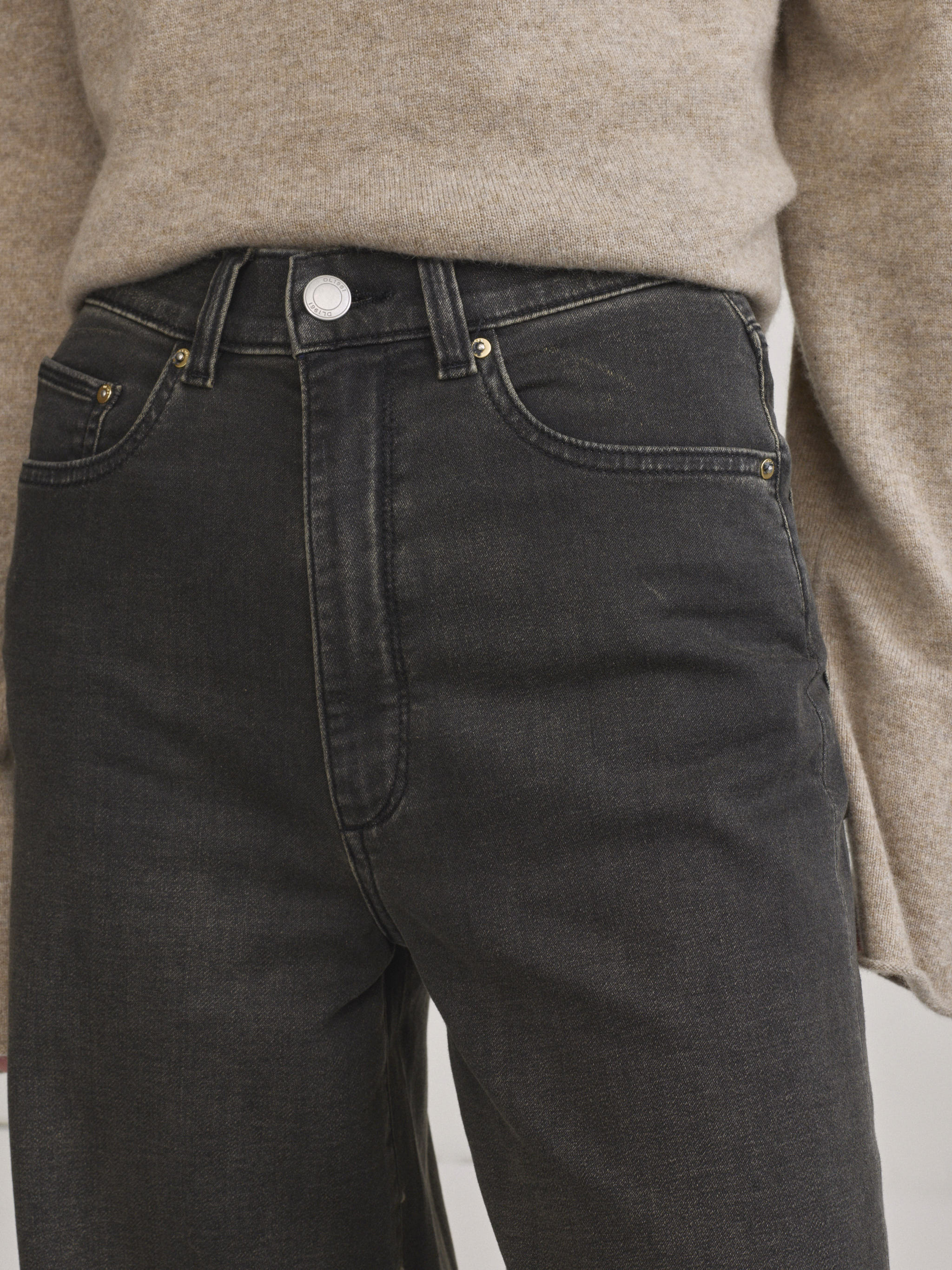 DL1961 Hepburn wide-leg high-rise jeans in washed black 'Rock', close-up of high-rise waistband and front pockets.