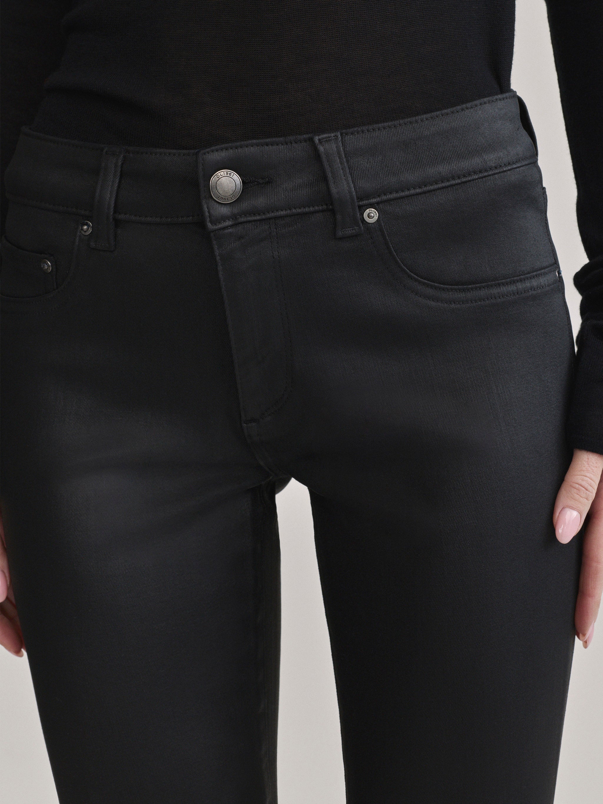 DL1961 Jessica Skinny Low-Rise coated jeans in Black Coated, close-up of button and pockets.