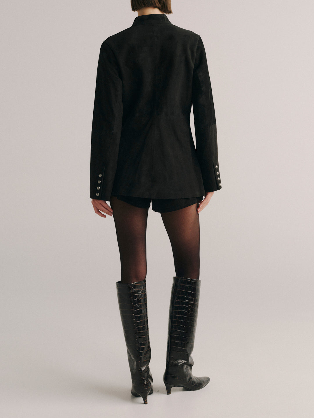 DL1961 Maria Suede Jacket in black suede, fitted stand-collar jacket, back view with flared cuffs and boots.