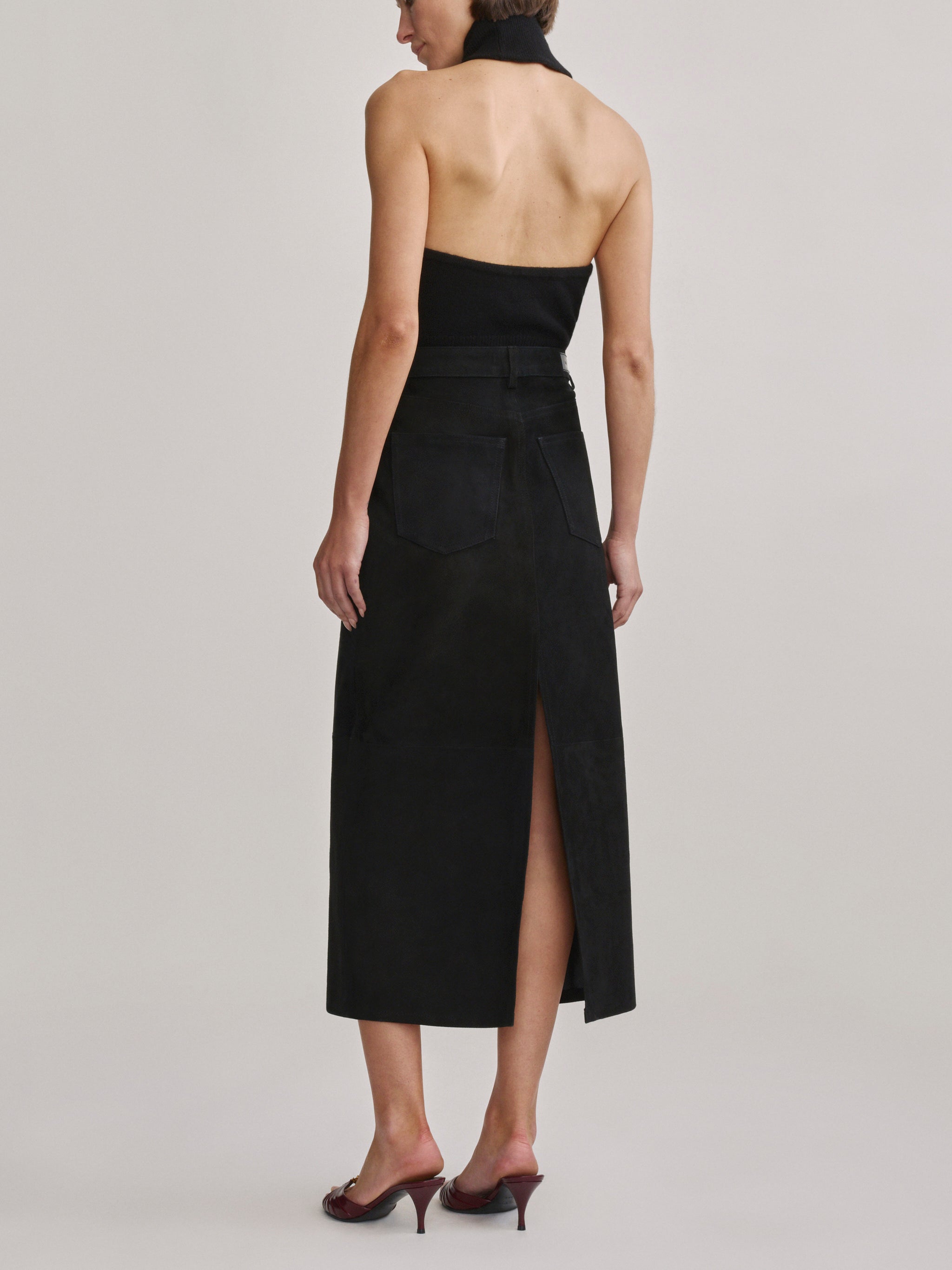 DL1961 Alma Suede Midi Skirt in Black Suede, back view showing rear slit and pockets.