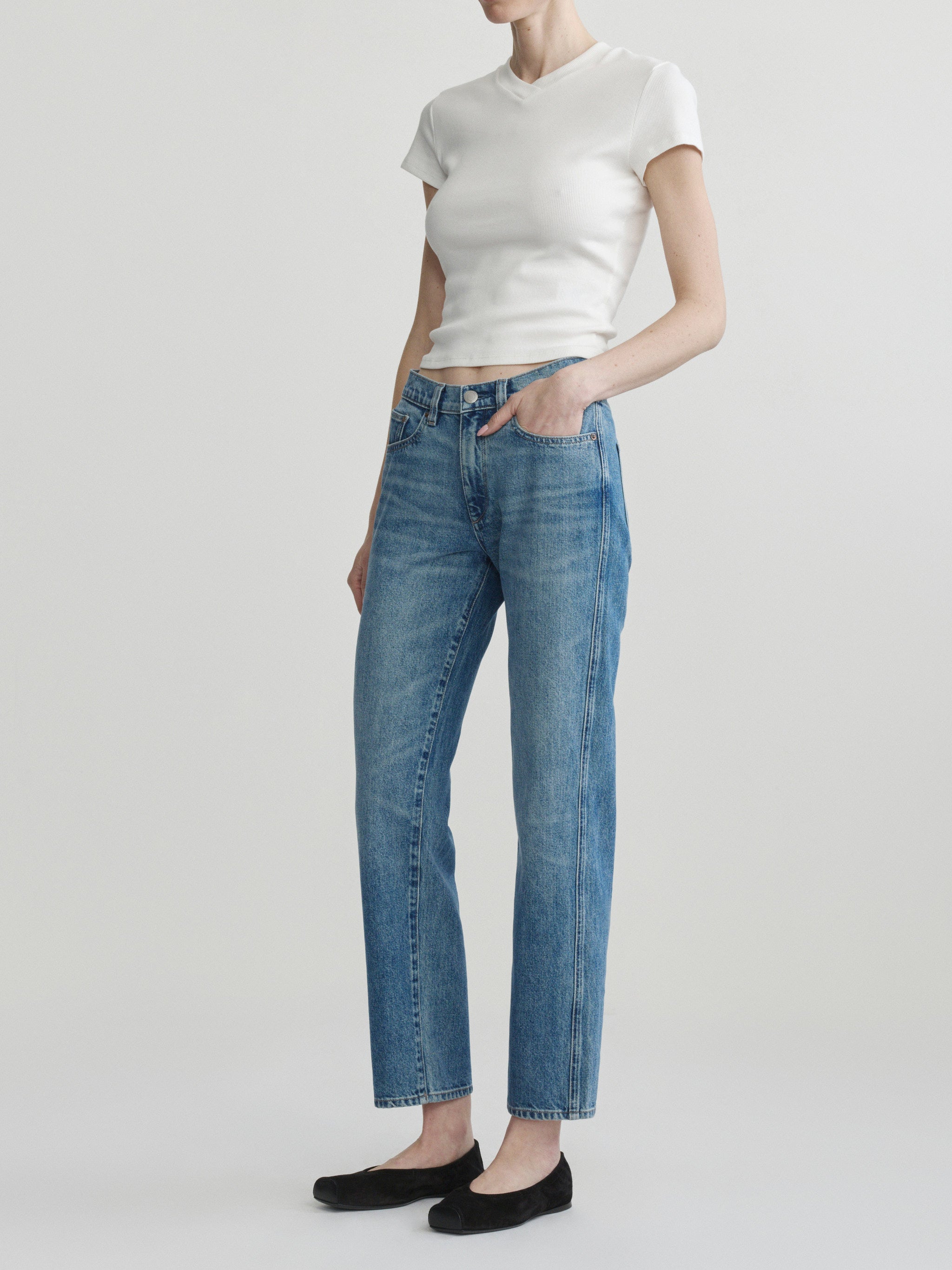 Dakota Slim Straight jeans in Endless Sea, model three-quarter view in studio, full-length.