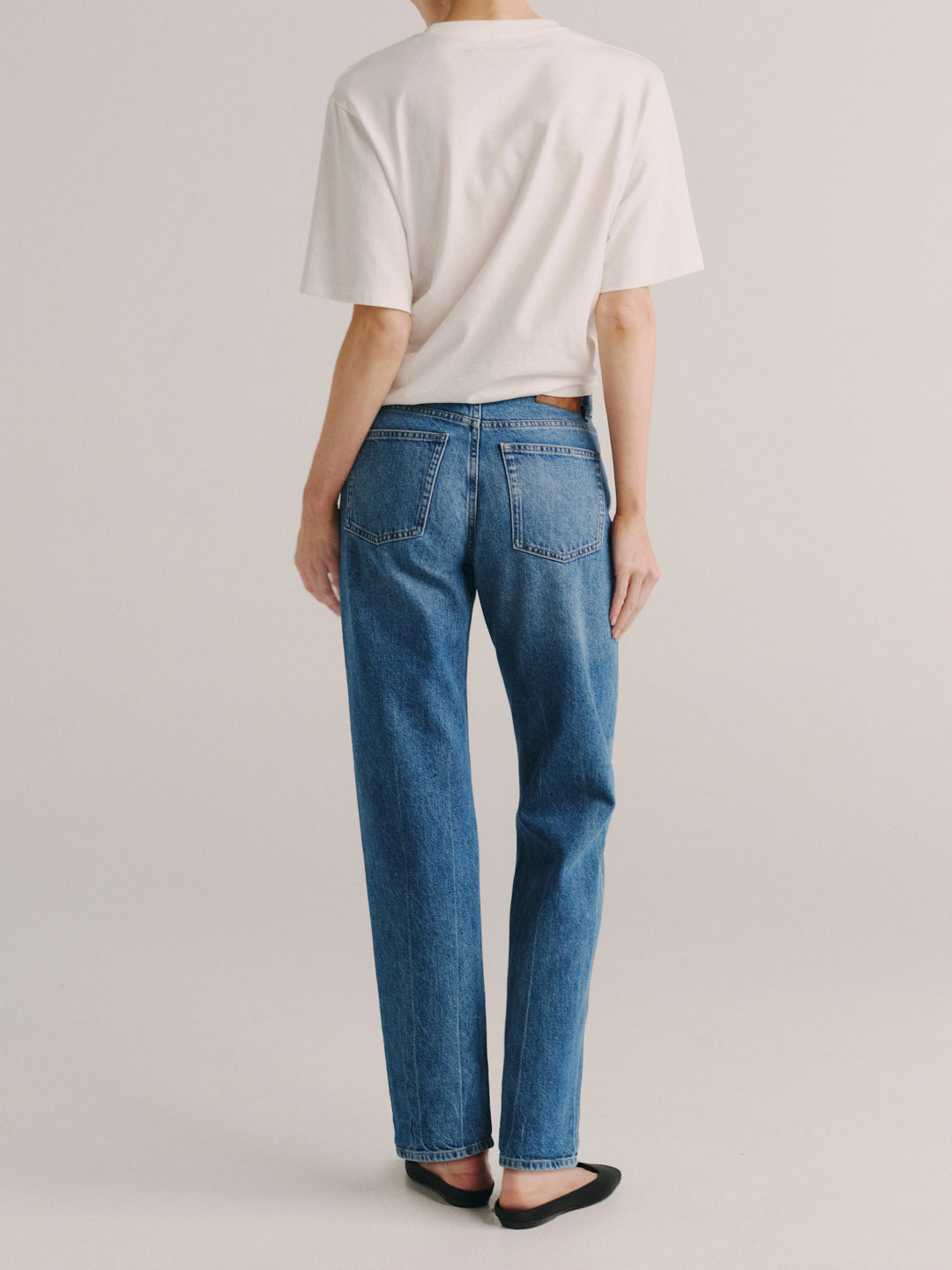Dakota Slim Straight jeans in Endless Sea, model back view in studio, full-length.