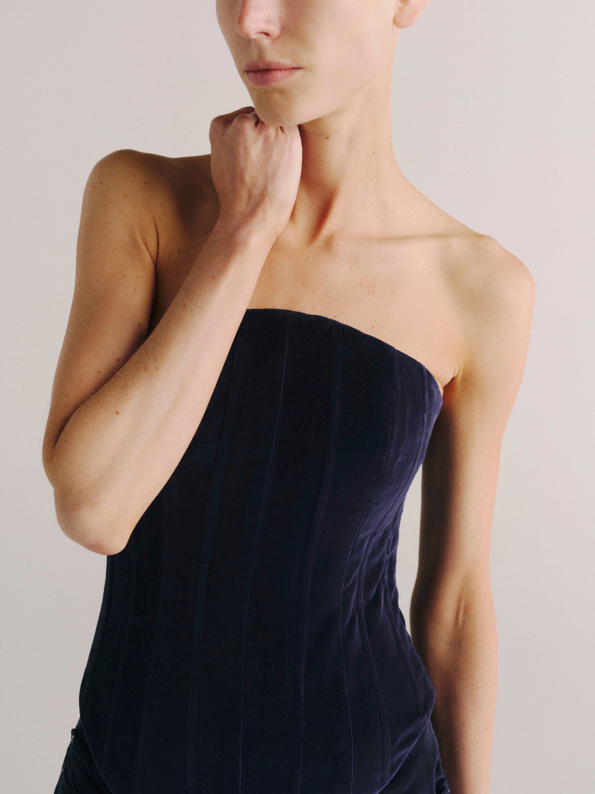 DL1961 women's strapless corset top in navy 'Ajax Velvet', close-up of the straight neckline and velvet boning seams.