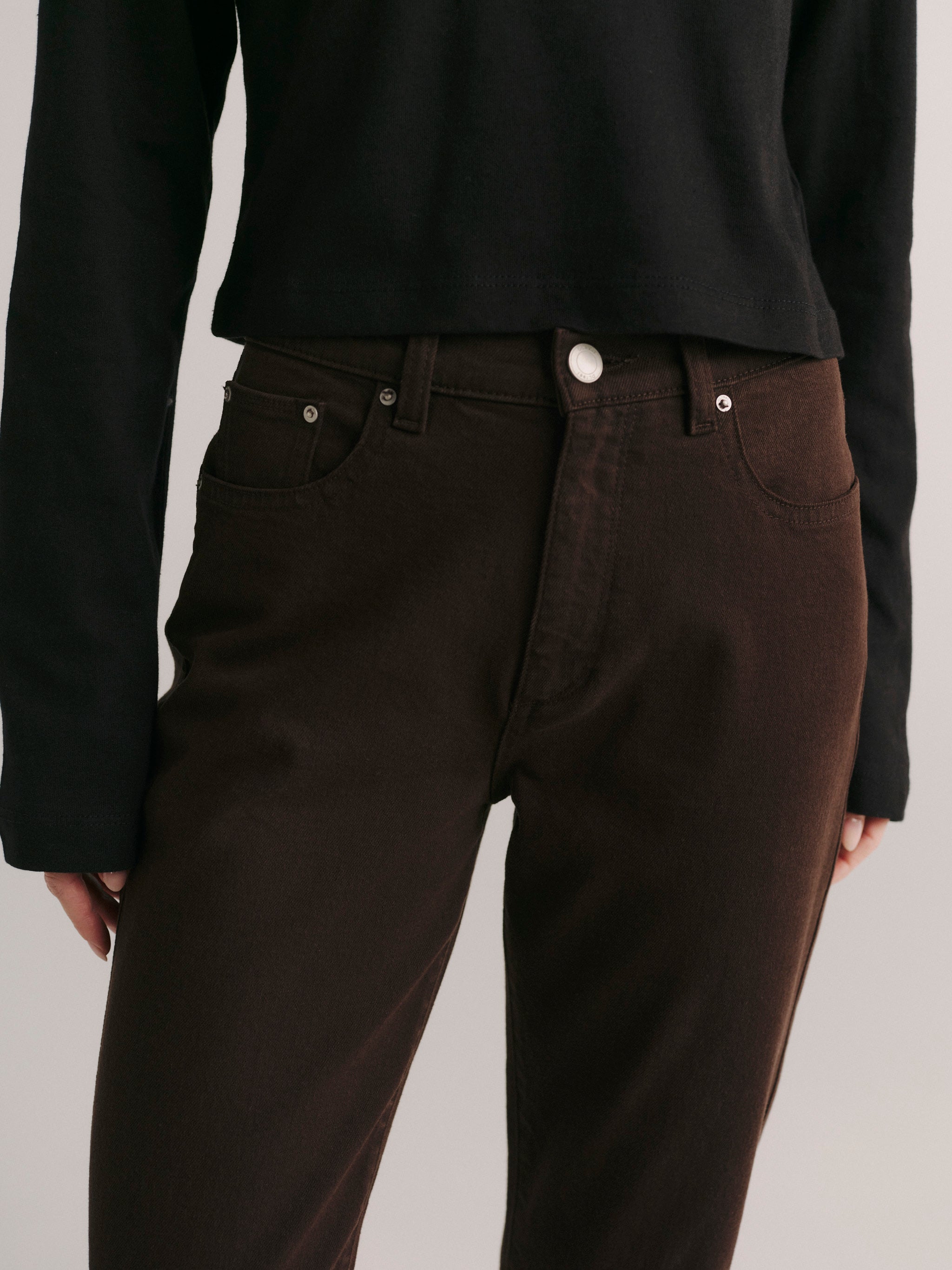 DL1961 women's Cate Stretch Straight High-Rise jeans in dark brown 'Tobacco', close-up of the high rise waist and front pocket.