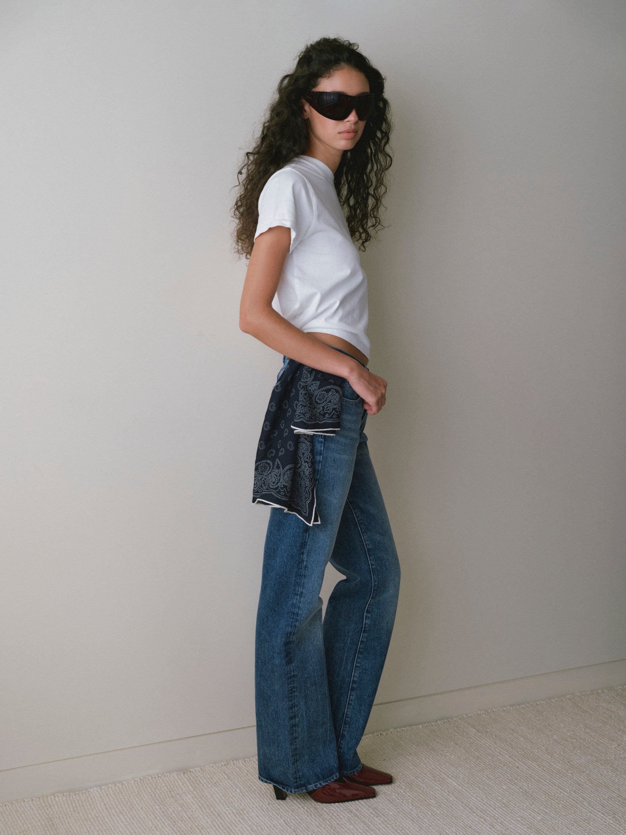 DL1961 women's Everyday tee in white, side view with medium blue jeans and a denim jacket held at the waist.