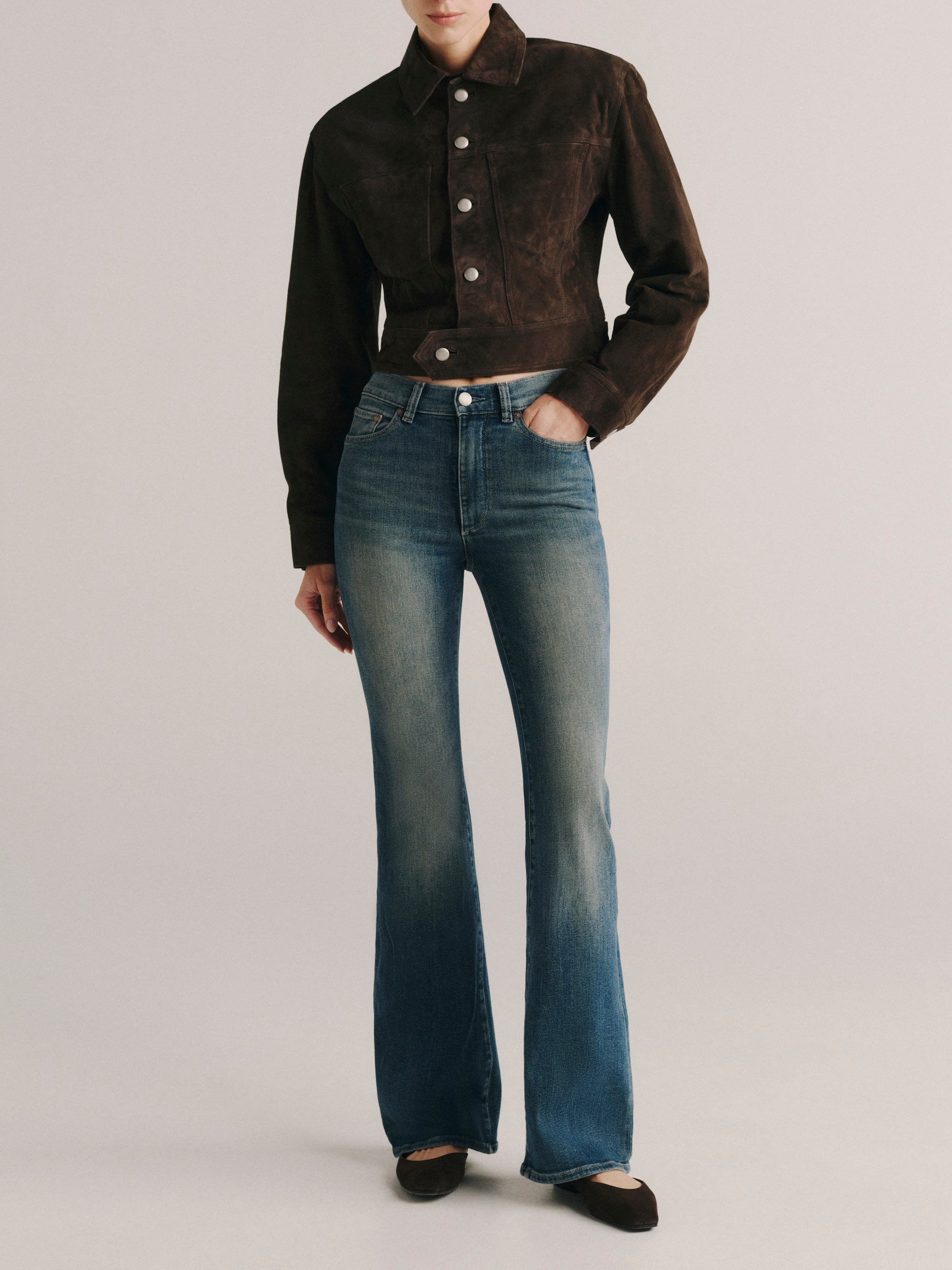 DL1961 women's Bridget Bootcut High Rise Instasculpt jeans in medium blue 'Eternal', front view with a brown suede jacket.