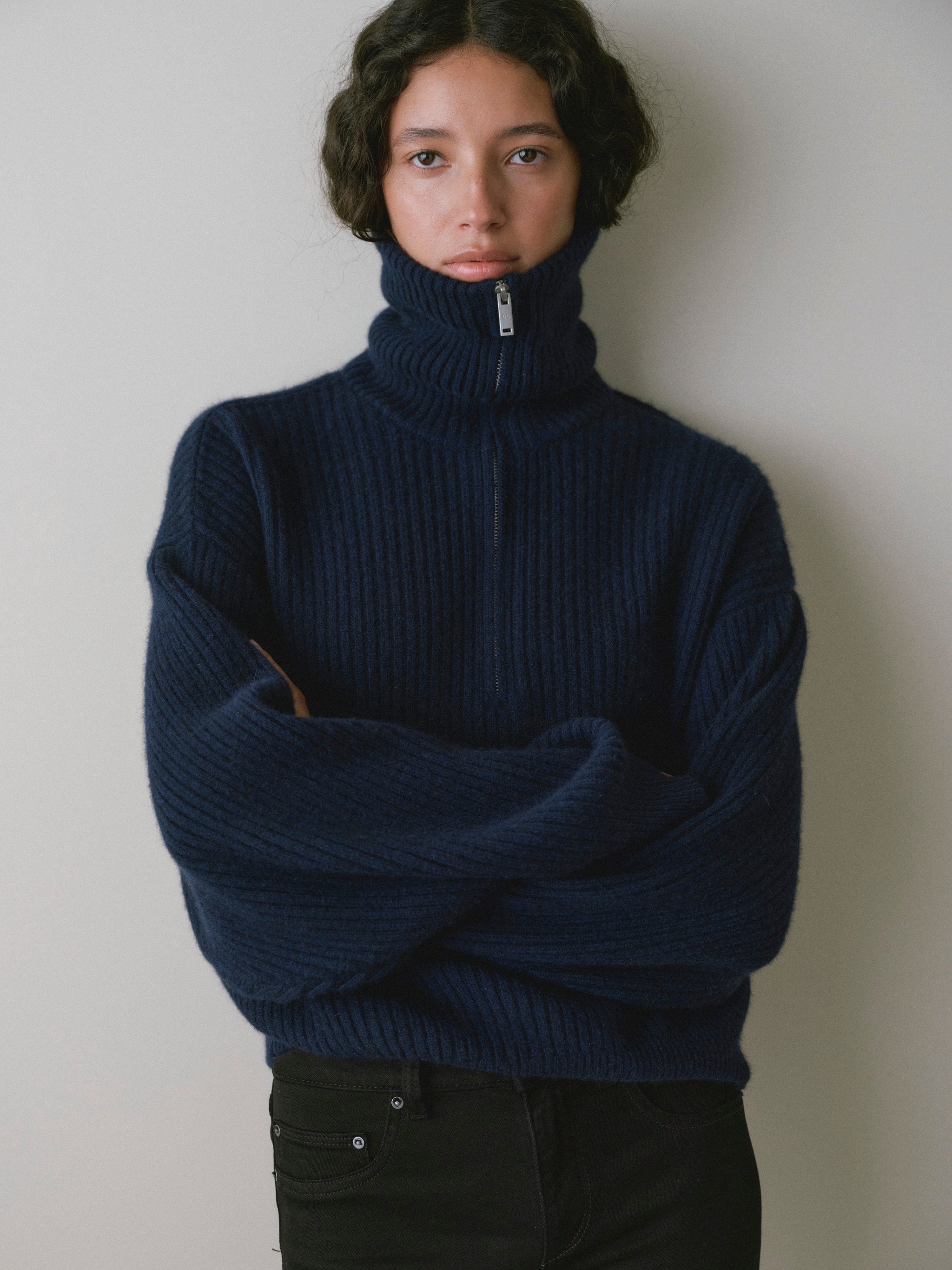 DL1961 women's Robbie oversized zip up sweater in navy 'Colter Bay', front view with arms crossed over black jeans.