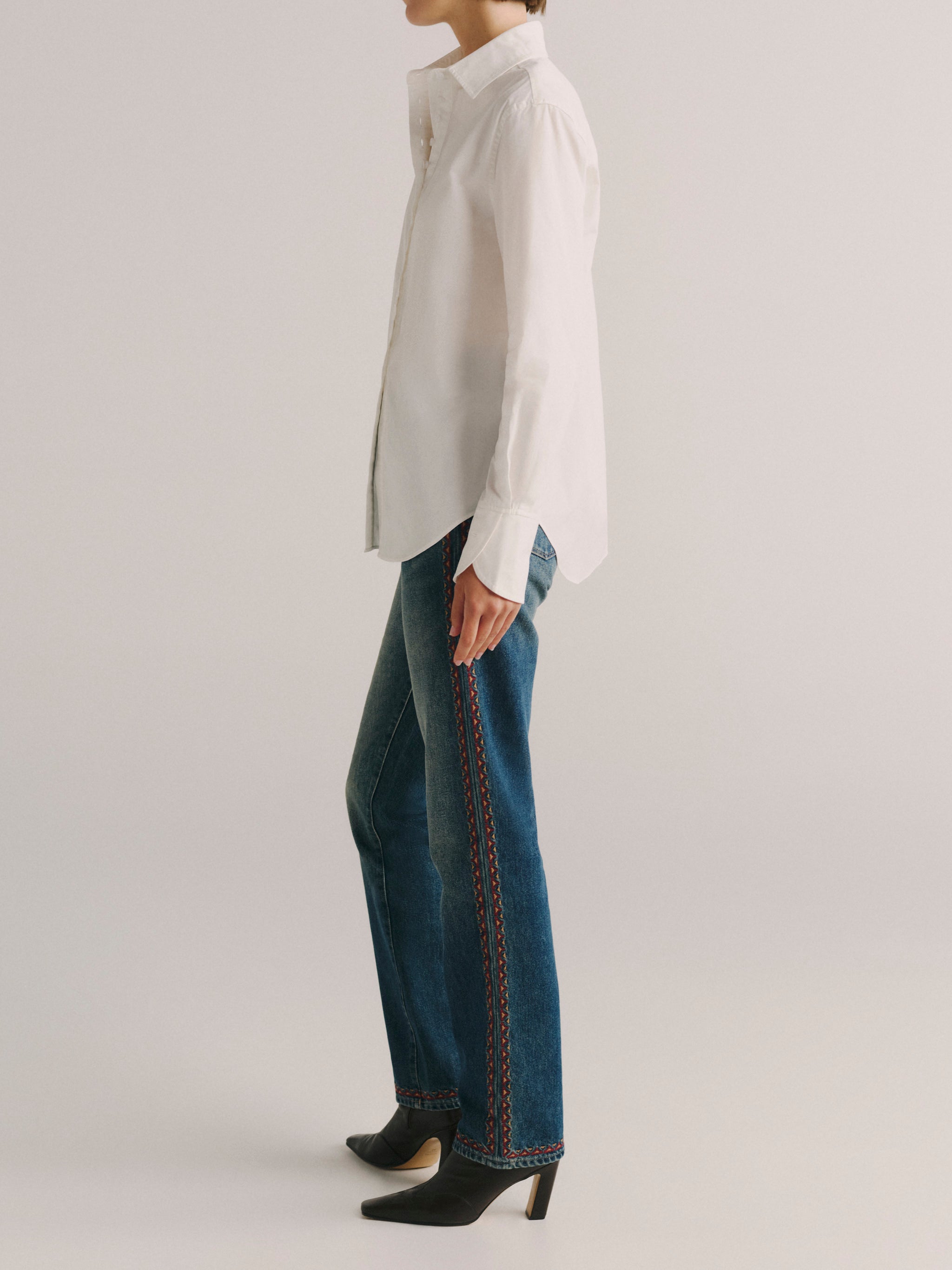 DL1961 women's Kaia poplin shirt in white, side view showing the relaxed fit and curved hem.