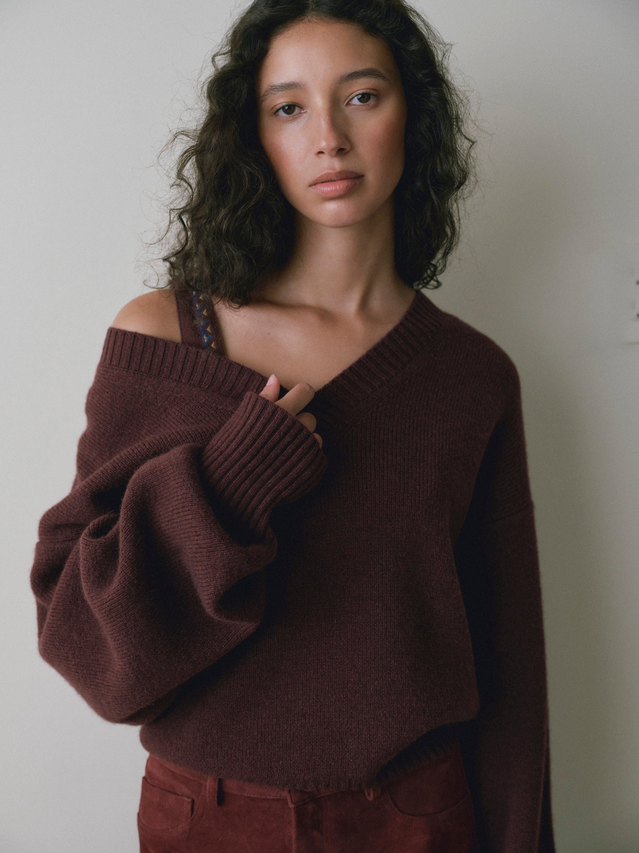 DL1961 women's Robbie oversized V-neck sweater in bordeaux, close-up worn off one shoulder showing the ribbed knit.