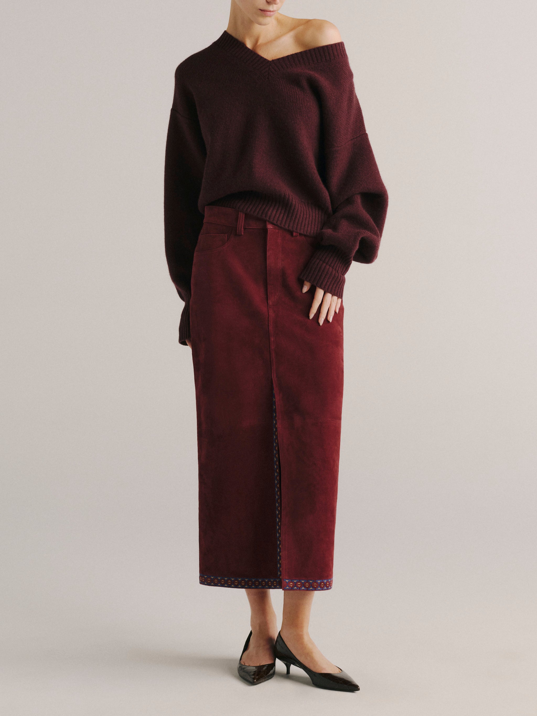 DL1961 women's Alma suede midi skirt in 'Burgundy Suede Embroidery', front view with a burgundy knit sweater.