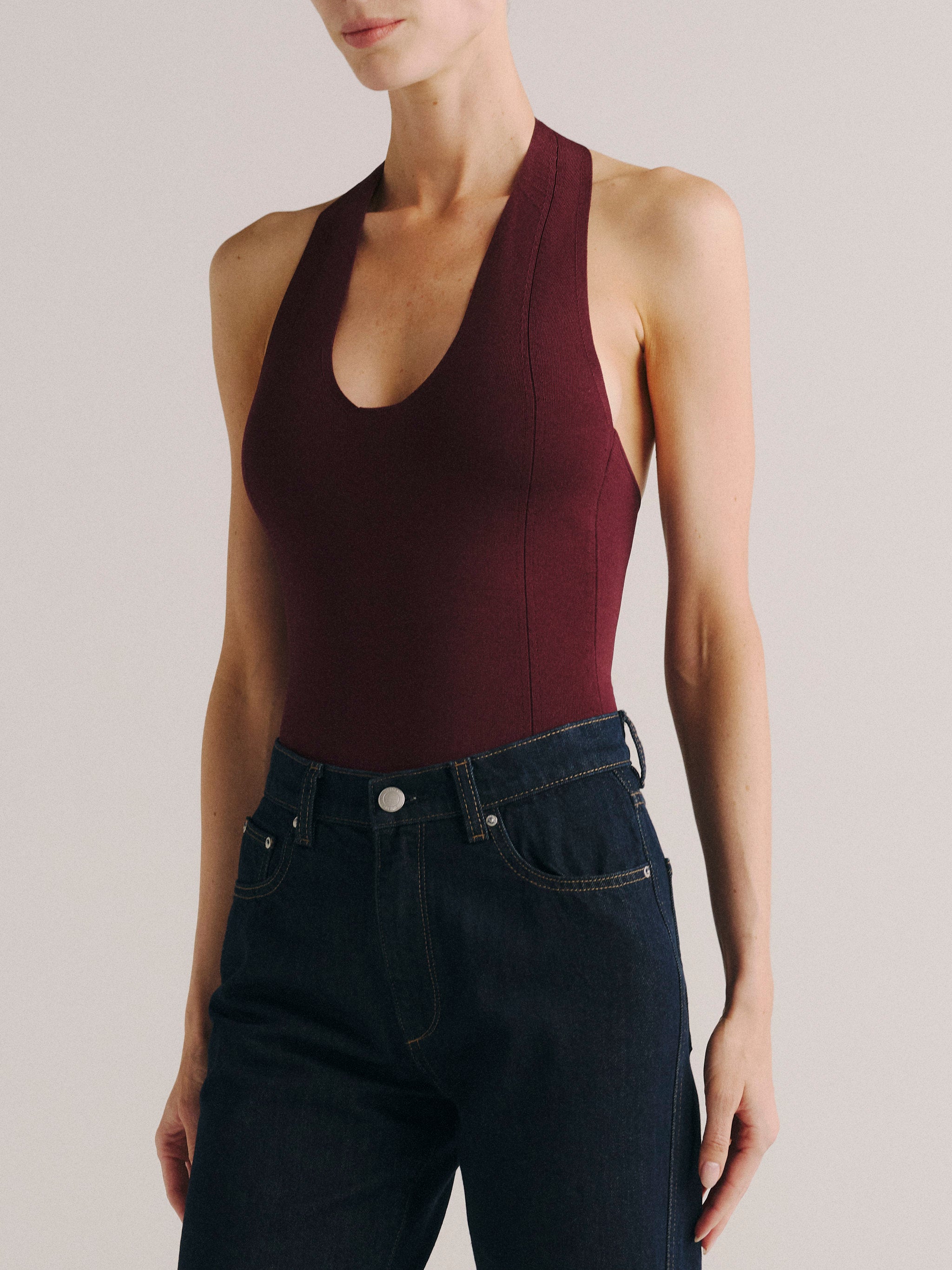 DL1961 women's Instasculpt halter bodysuit in burgundy 'Red Mountain', front view with dark indigo jeans.