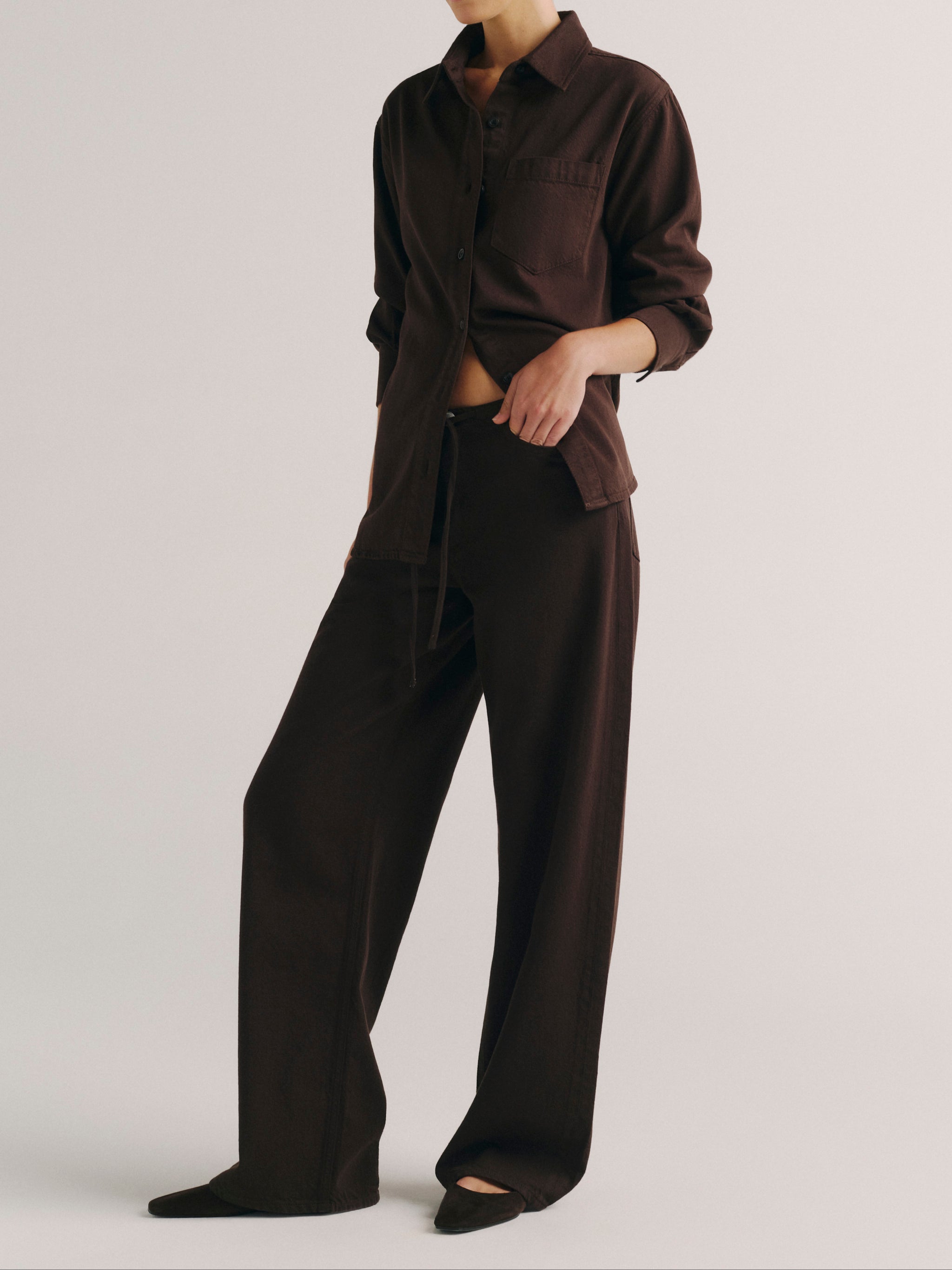 DL1961 women's Faye oversized denim shirt in dark brown 'Tobacco Aura', angled front view with sleeves rolled.