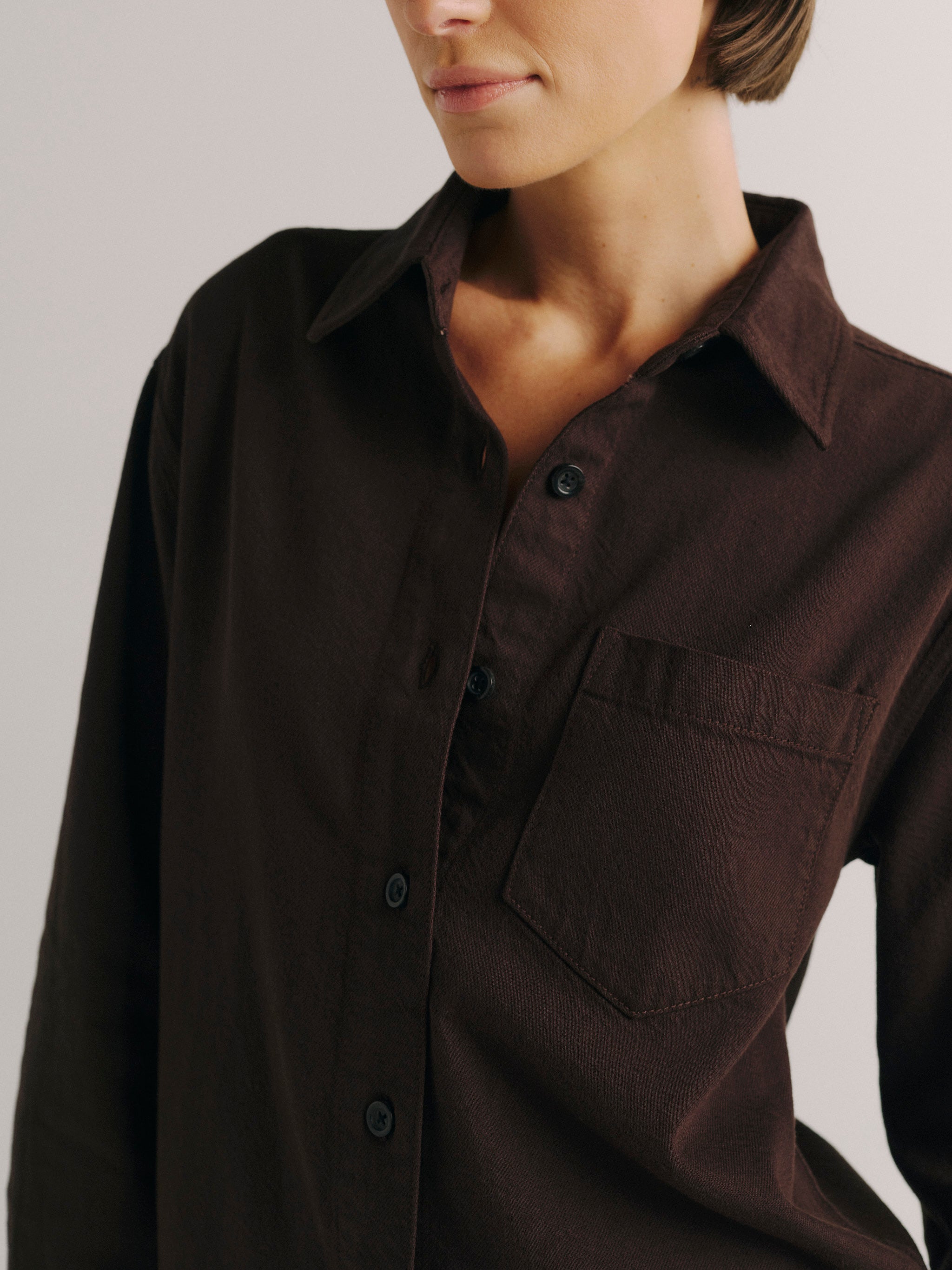DL1961 women's Faye oversized denim shirt in dark brown 'Tobacco Aura', close-up of the collar, placket and chest pocket.