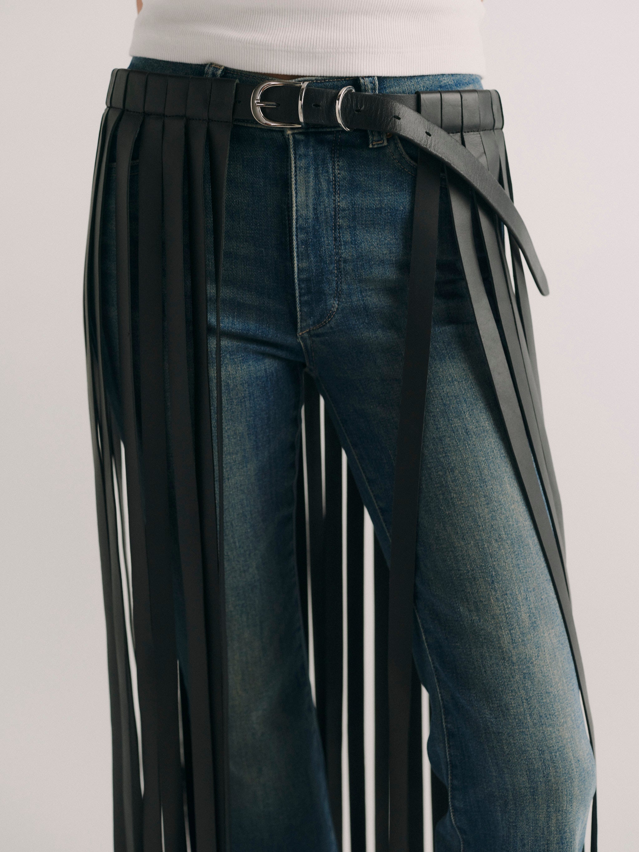 DL1961 fringe leather belt in black, close-up of the buckle fastening and leather strap.
