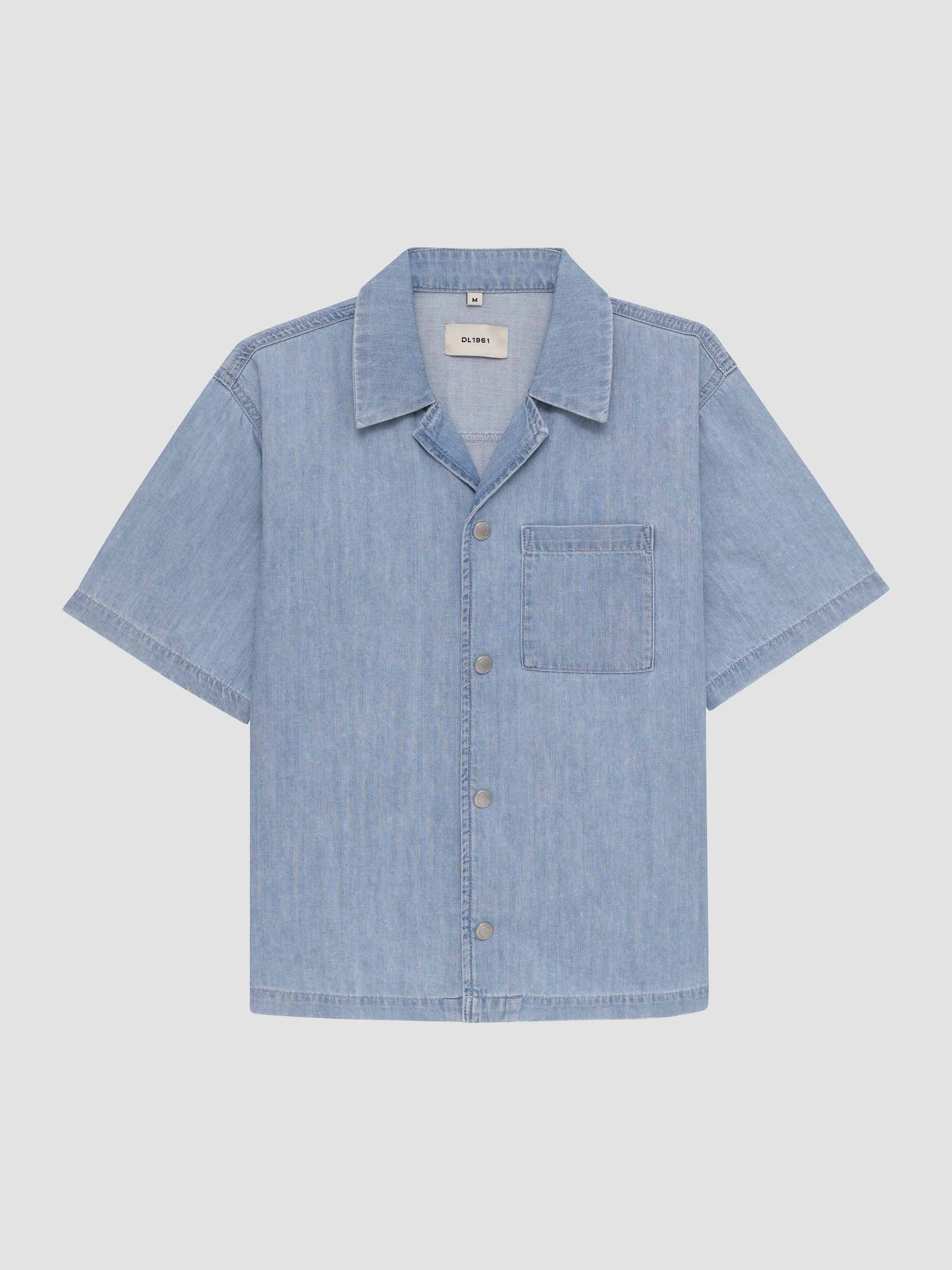 Light blue denim shirt on a light gray background
