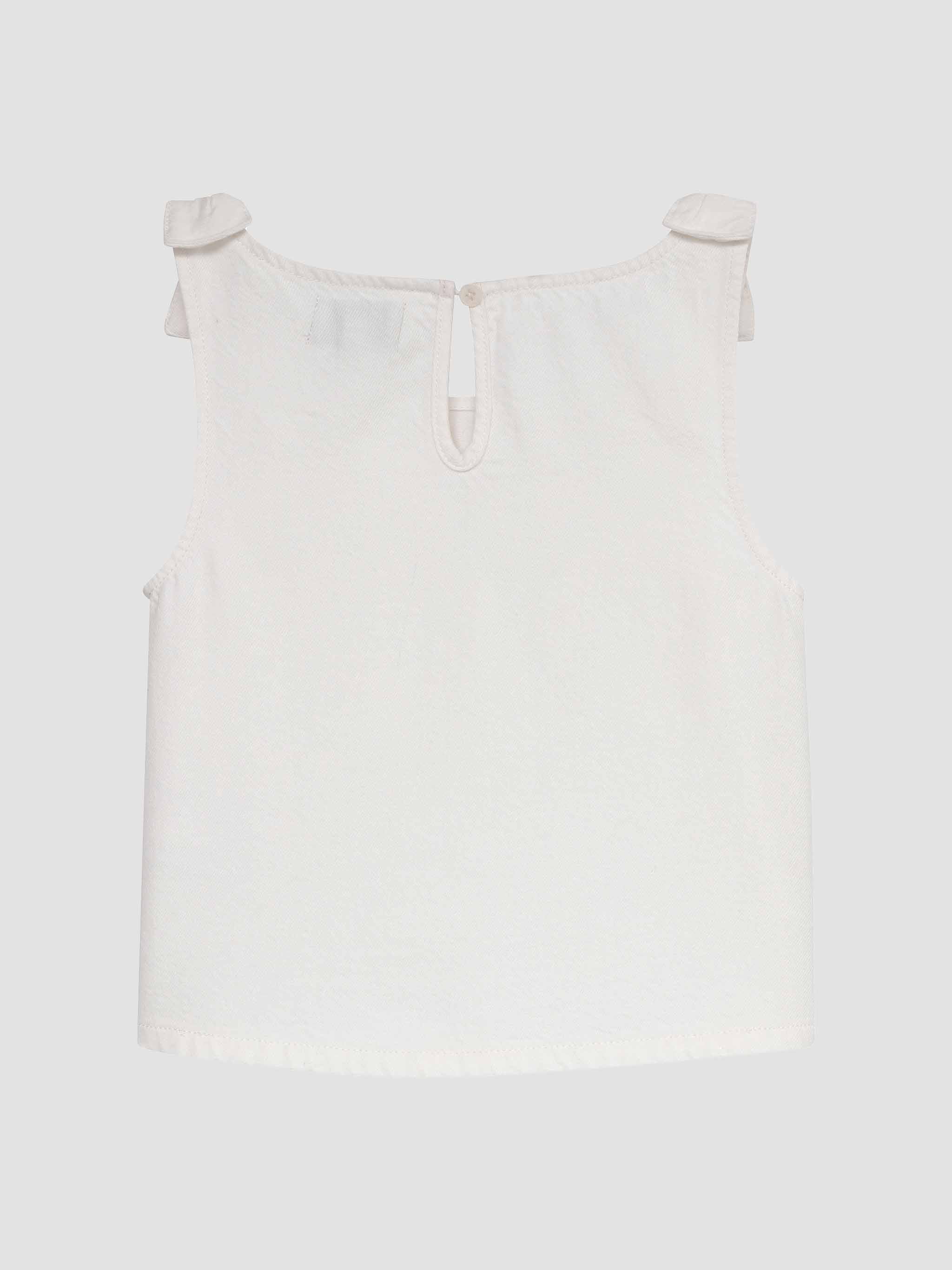 White sleeveless top with thin straps on a light gray background