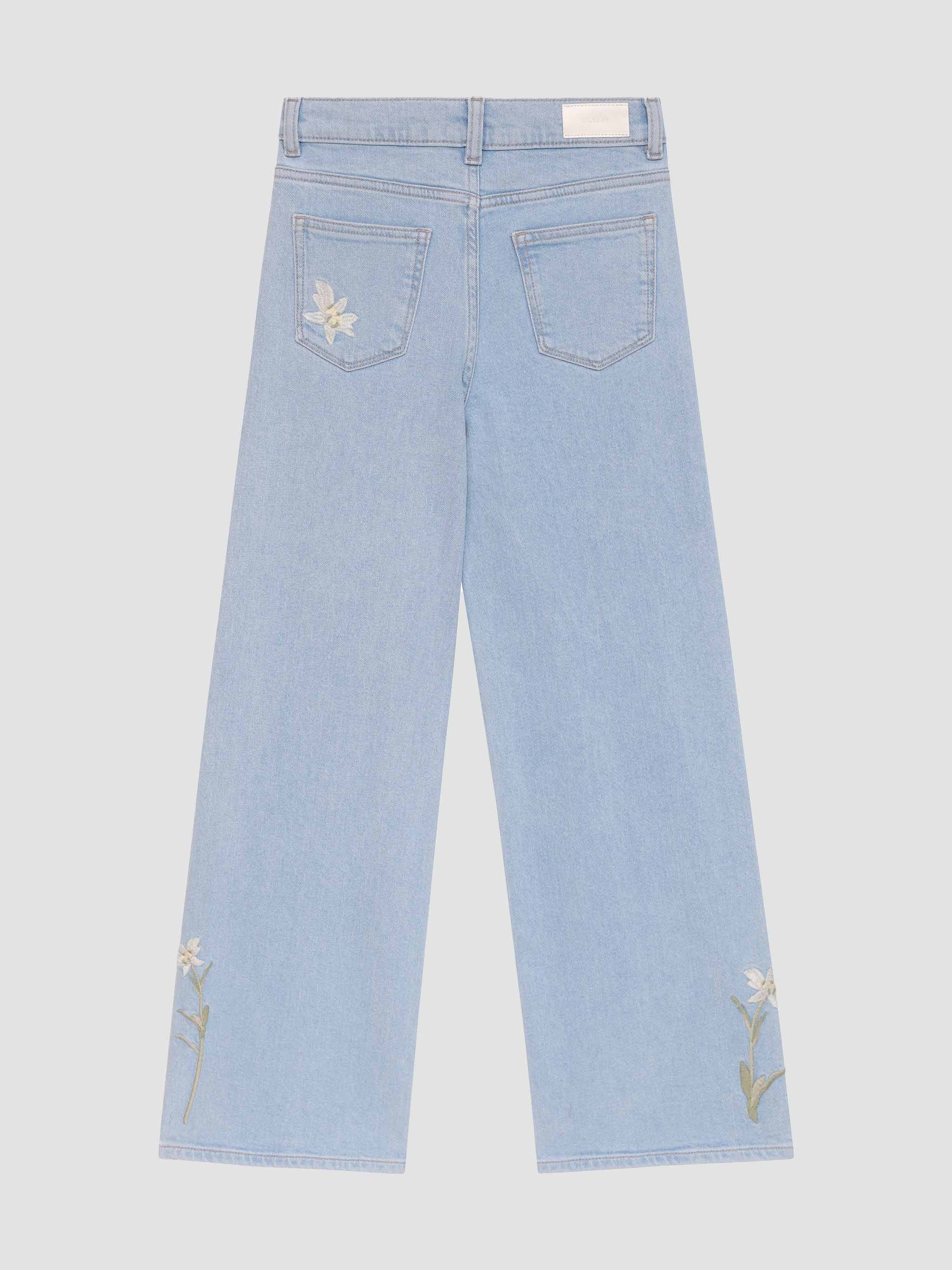 Light blue jeans with floral embroidery on a white background