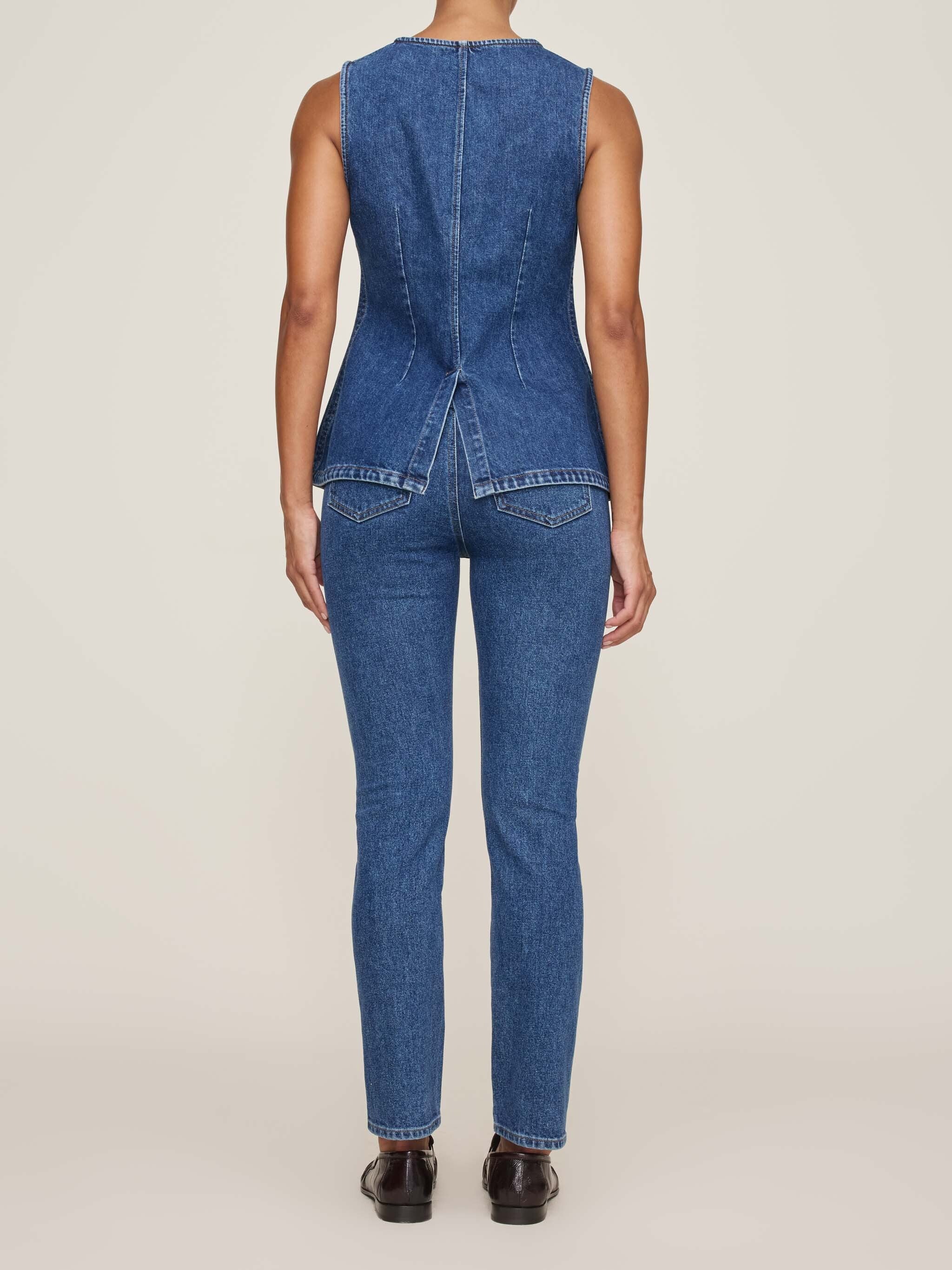 Blue denim jumpsuit on a plain background