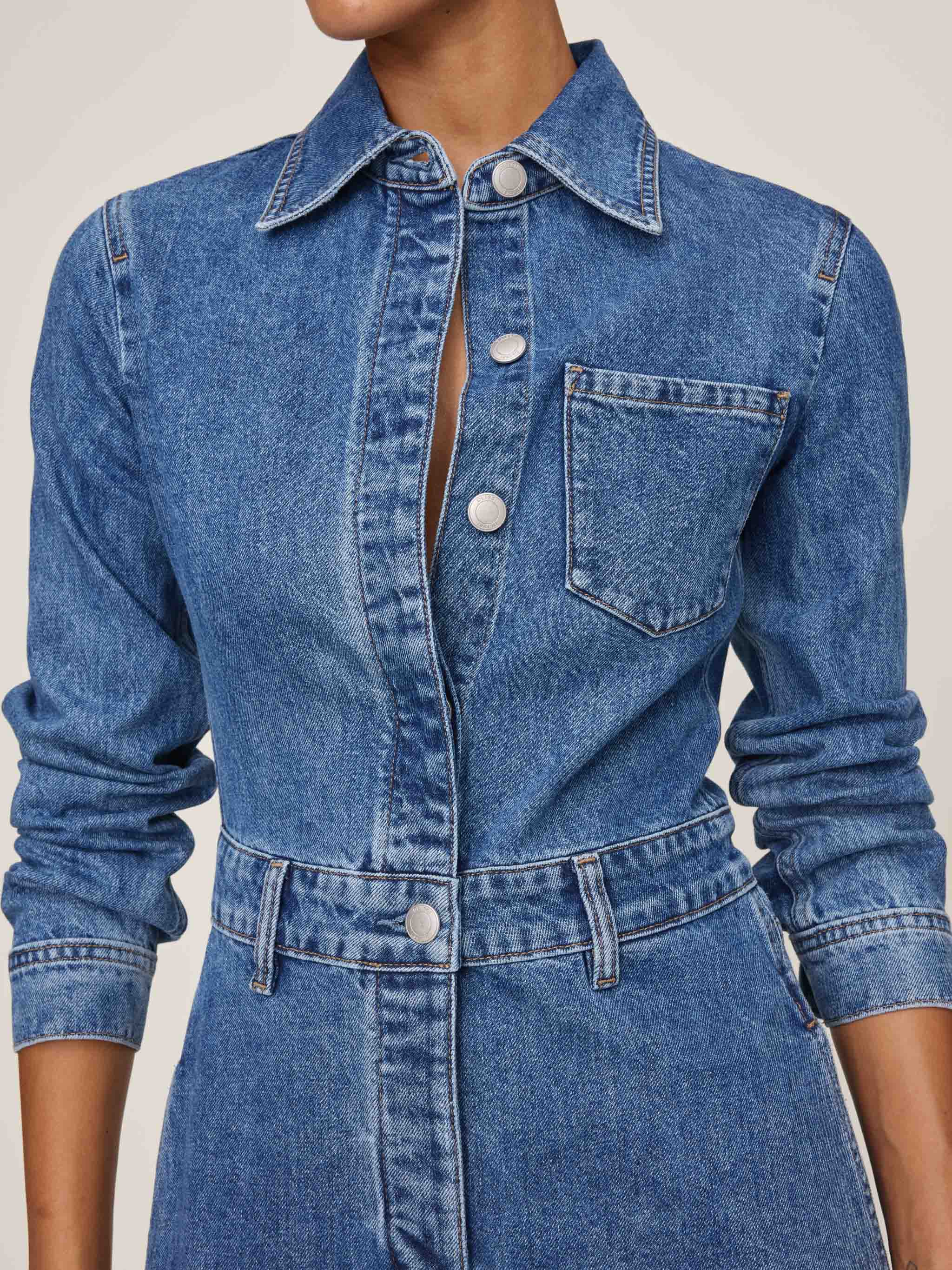 Blue denim dress with a collar and buttons on a neutral background
