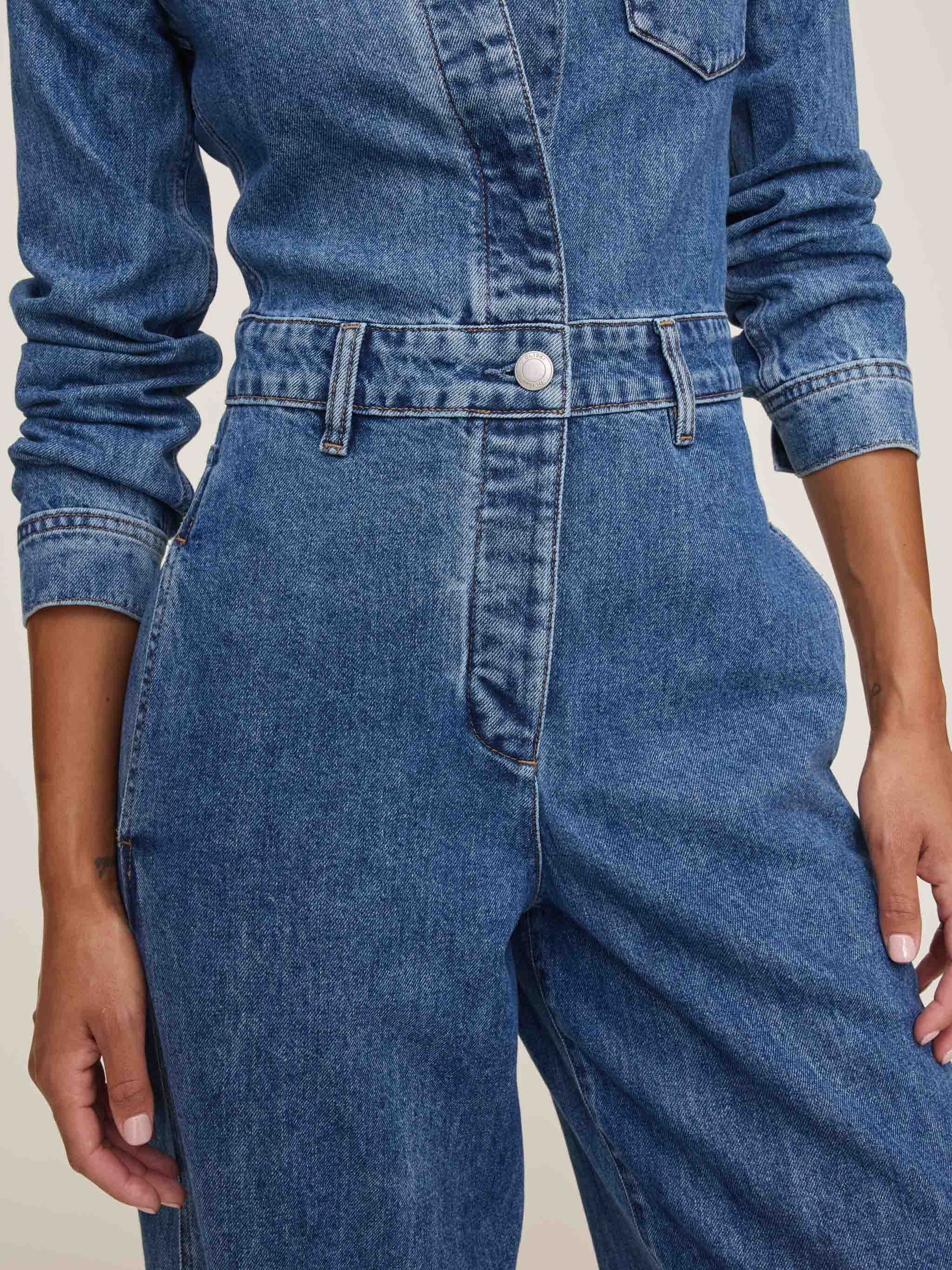 Blue denim jumpsuit on a neutral background