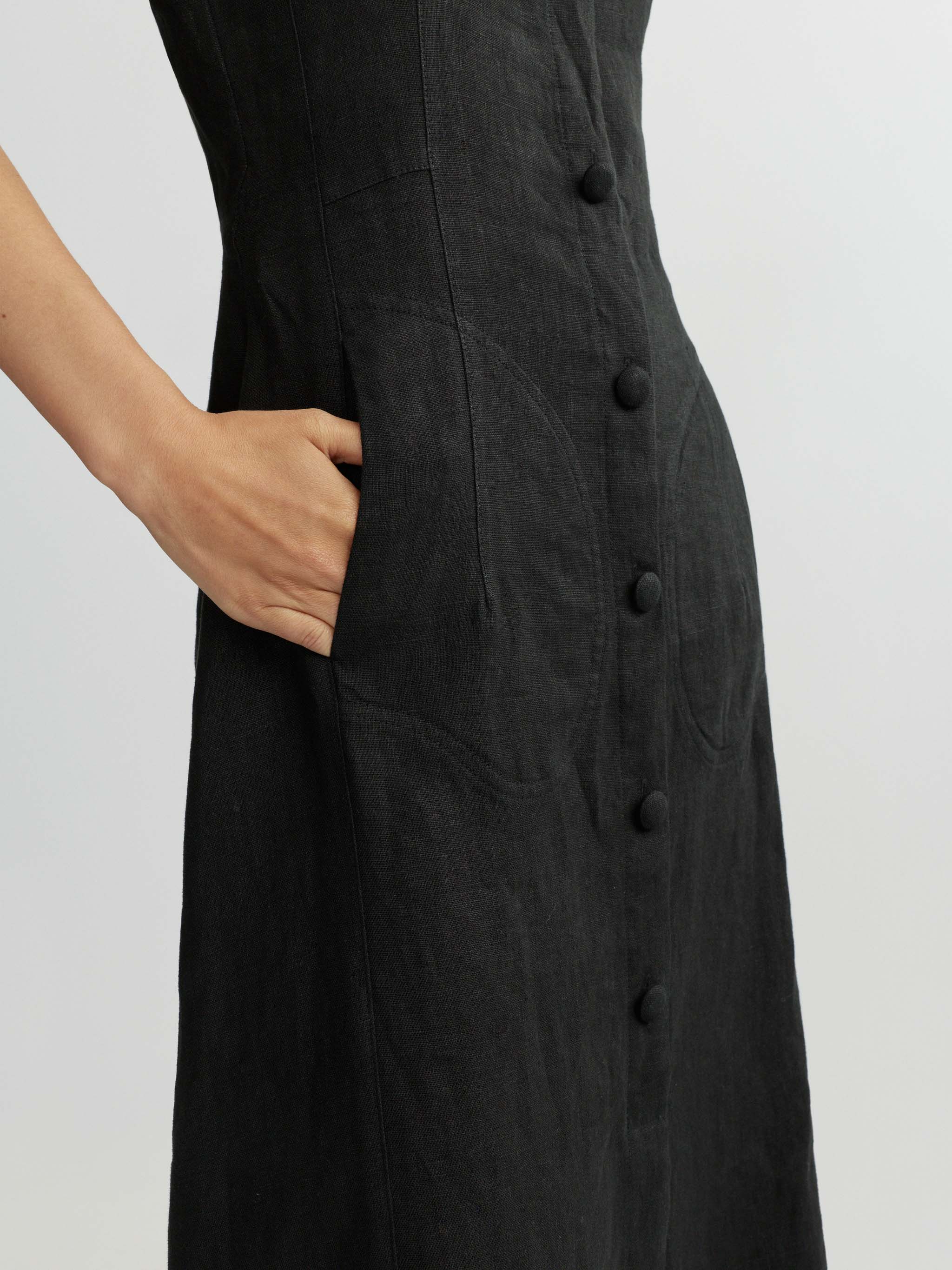 Black dress with buttons on a plain background