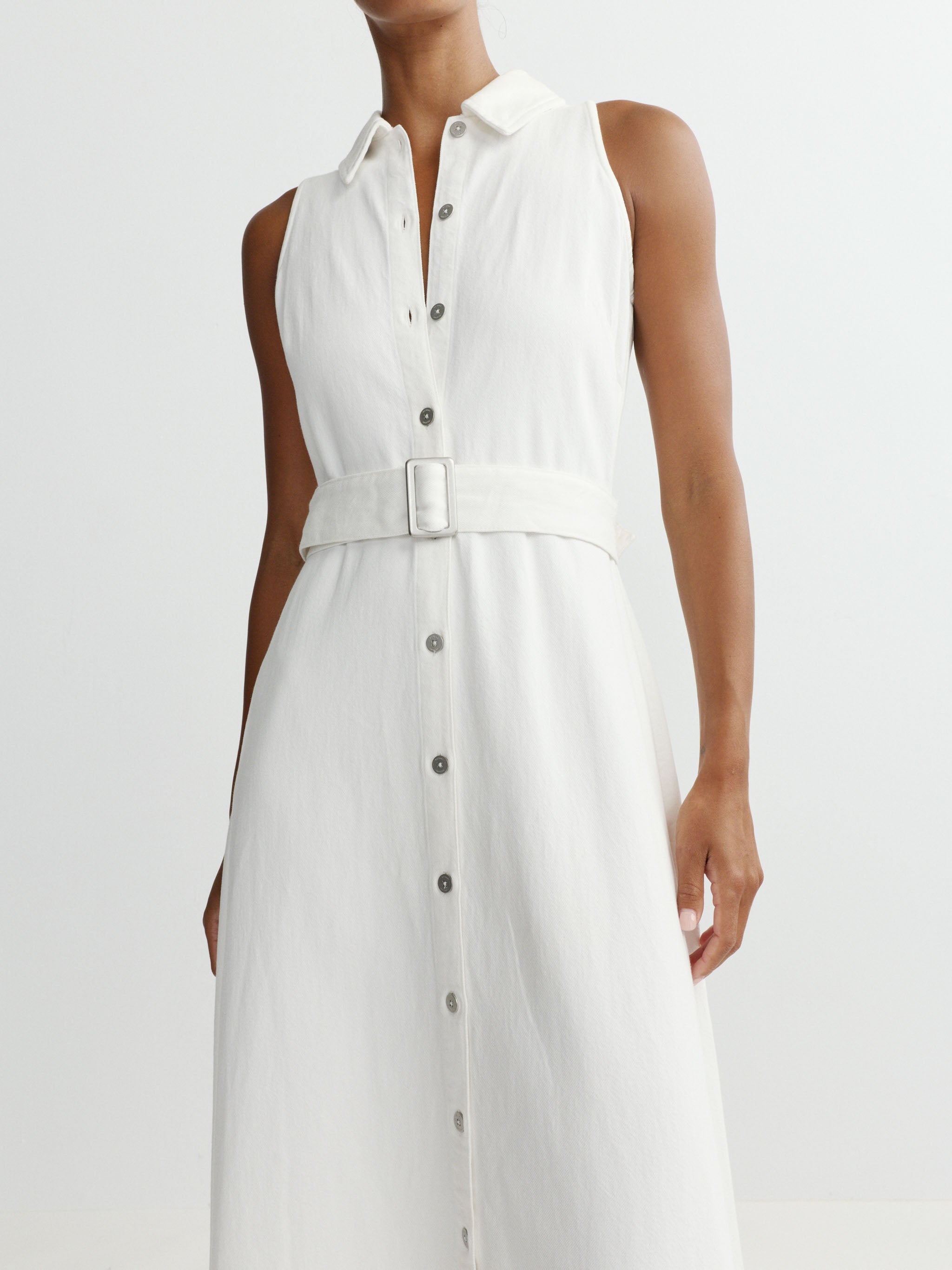 White sleeveless dress with buttons on a plain background