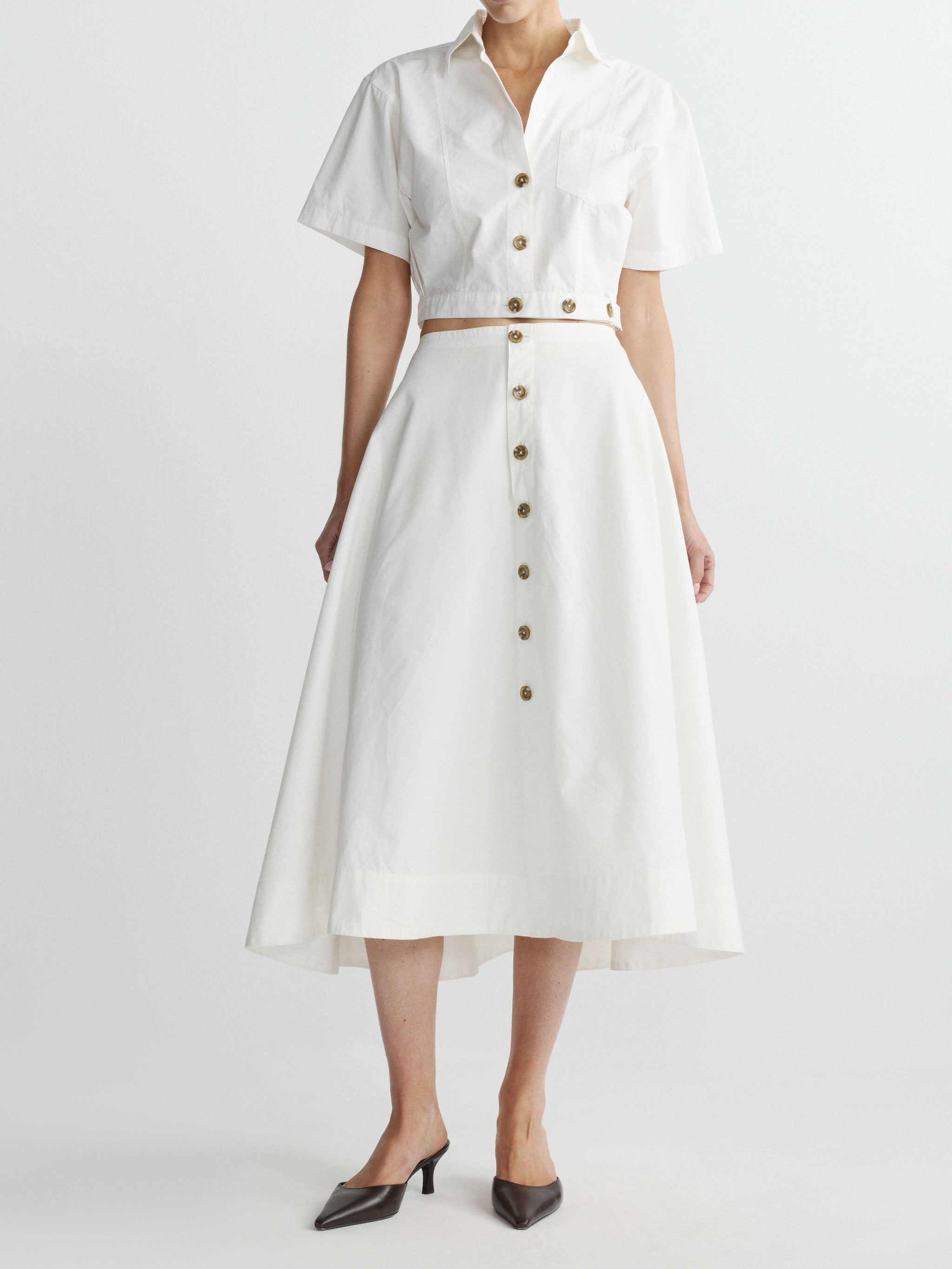 White top and skirt with button details on a white background