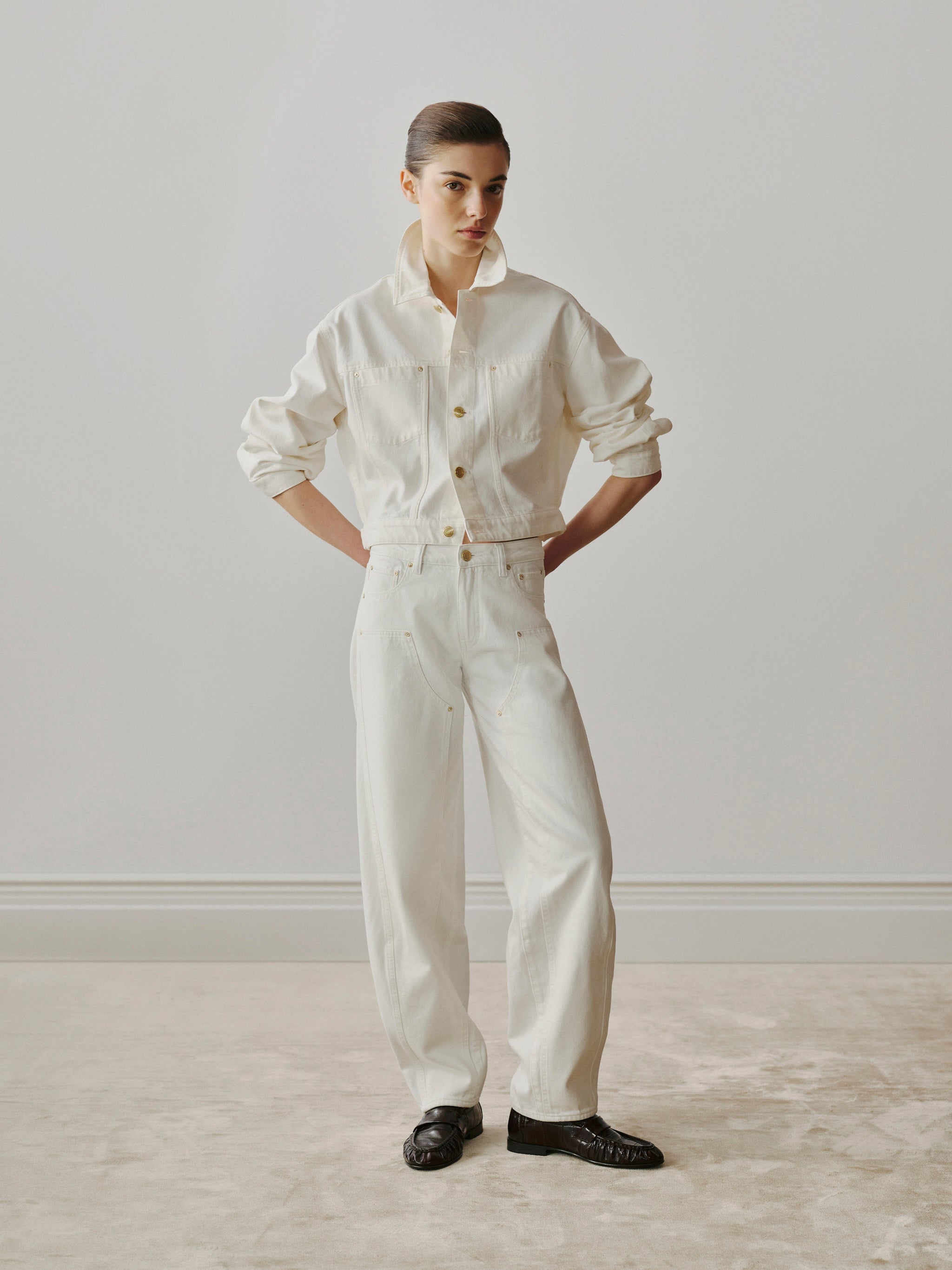 Person wearing a white outfit standing against a plain background