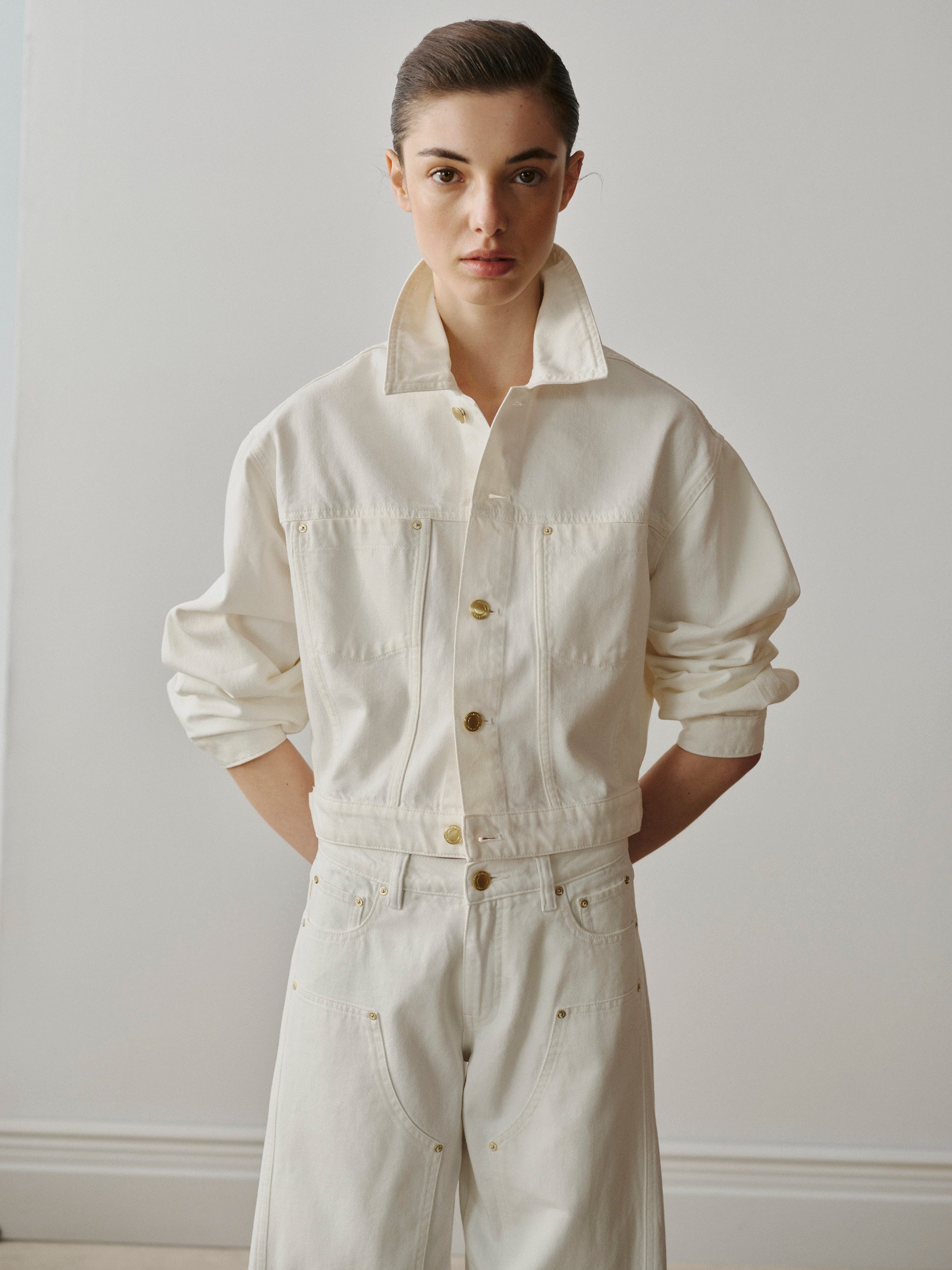 Person wearing a white jumpsuit against a plain background