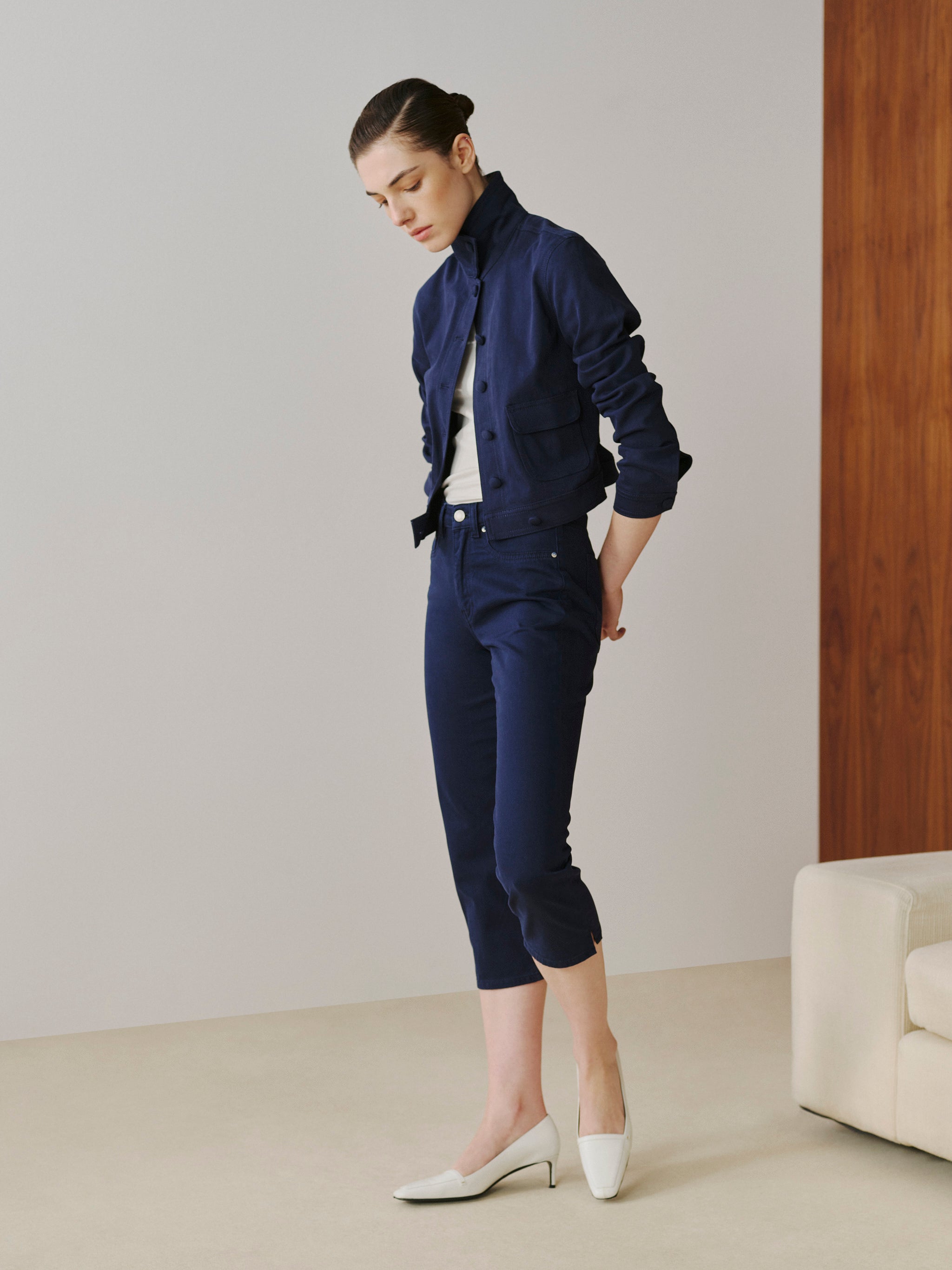 Woman wearing a navy outfit with a white background