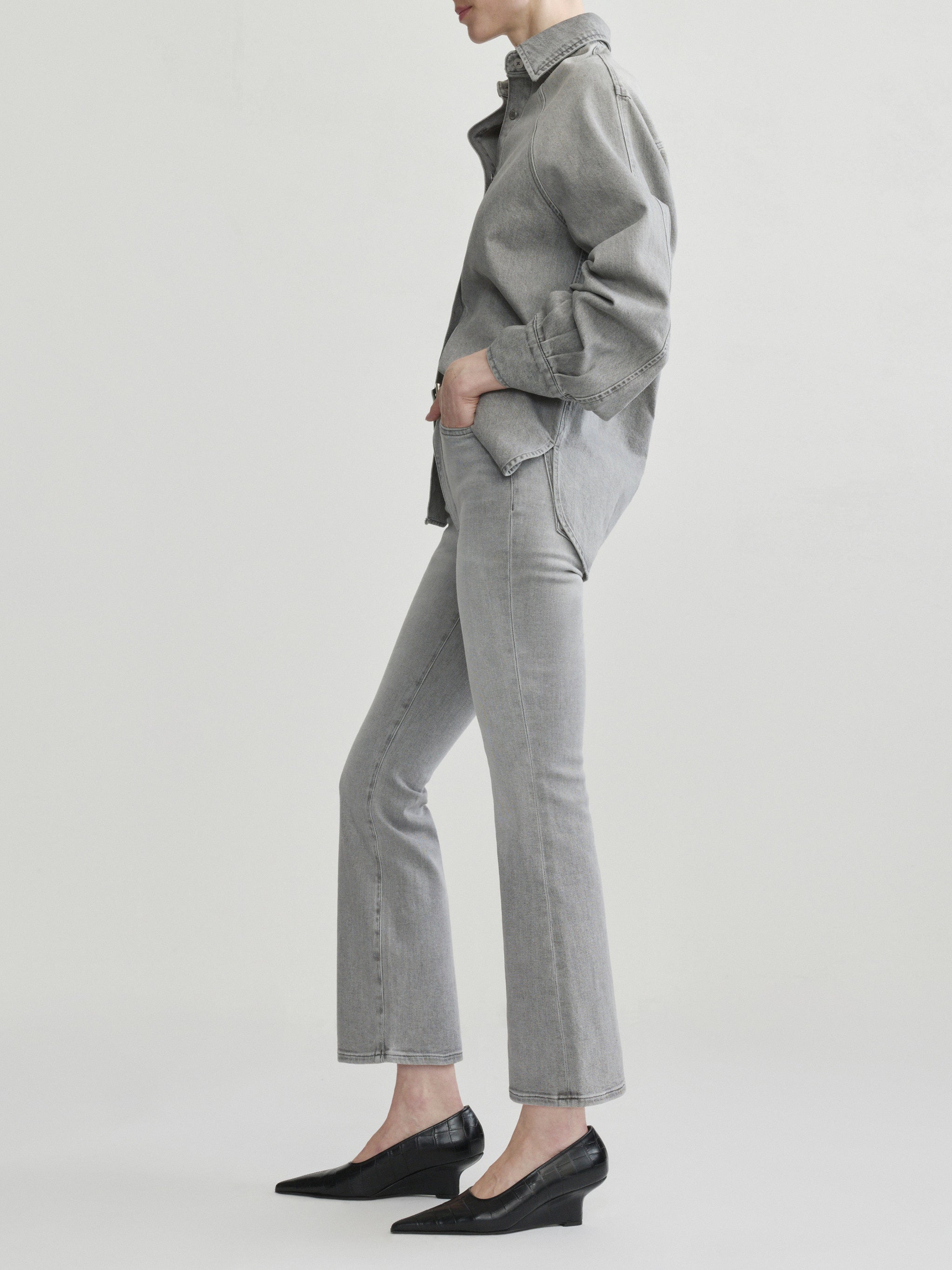 Mika Shirt in Light Smoke on a model with grey jeans, studio full-length side profile view.