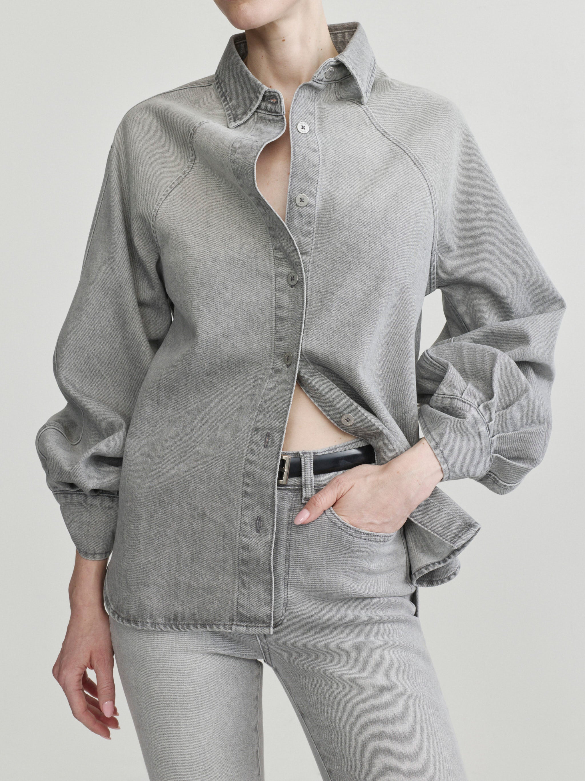 Mika Shirt in Light Smoke on a model, hands in pockets, studio portrait crop of open shirt.