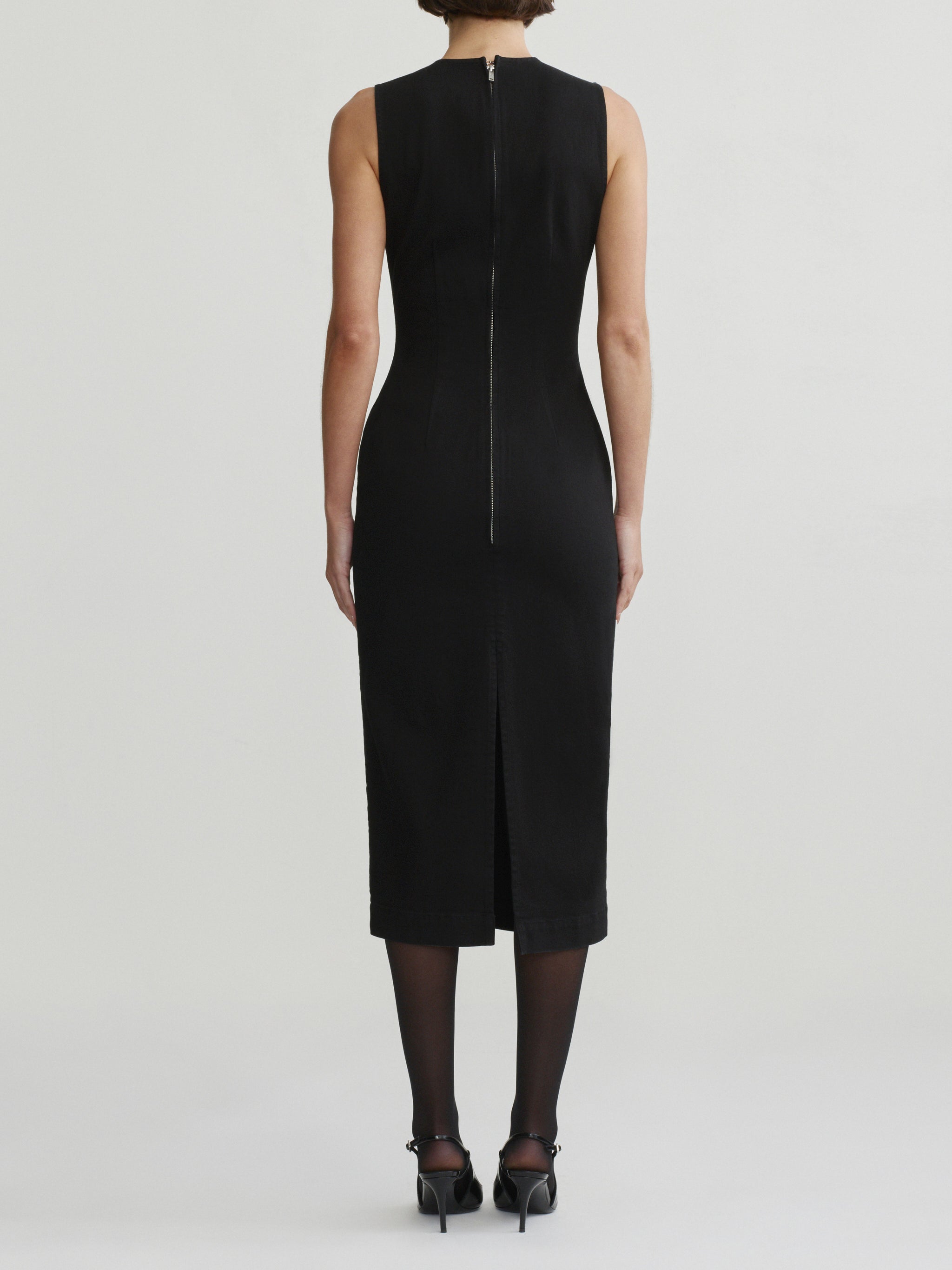 Esme Dress in Black on a model with sheer tights, studio full-length back view.