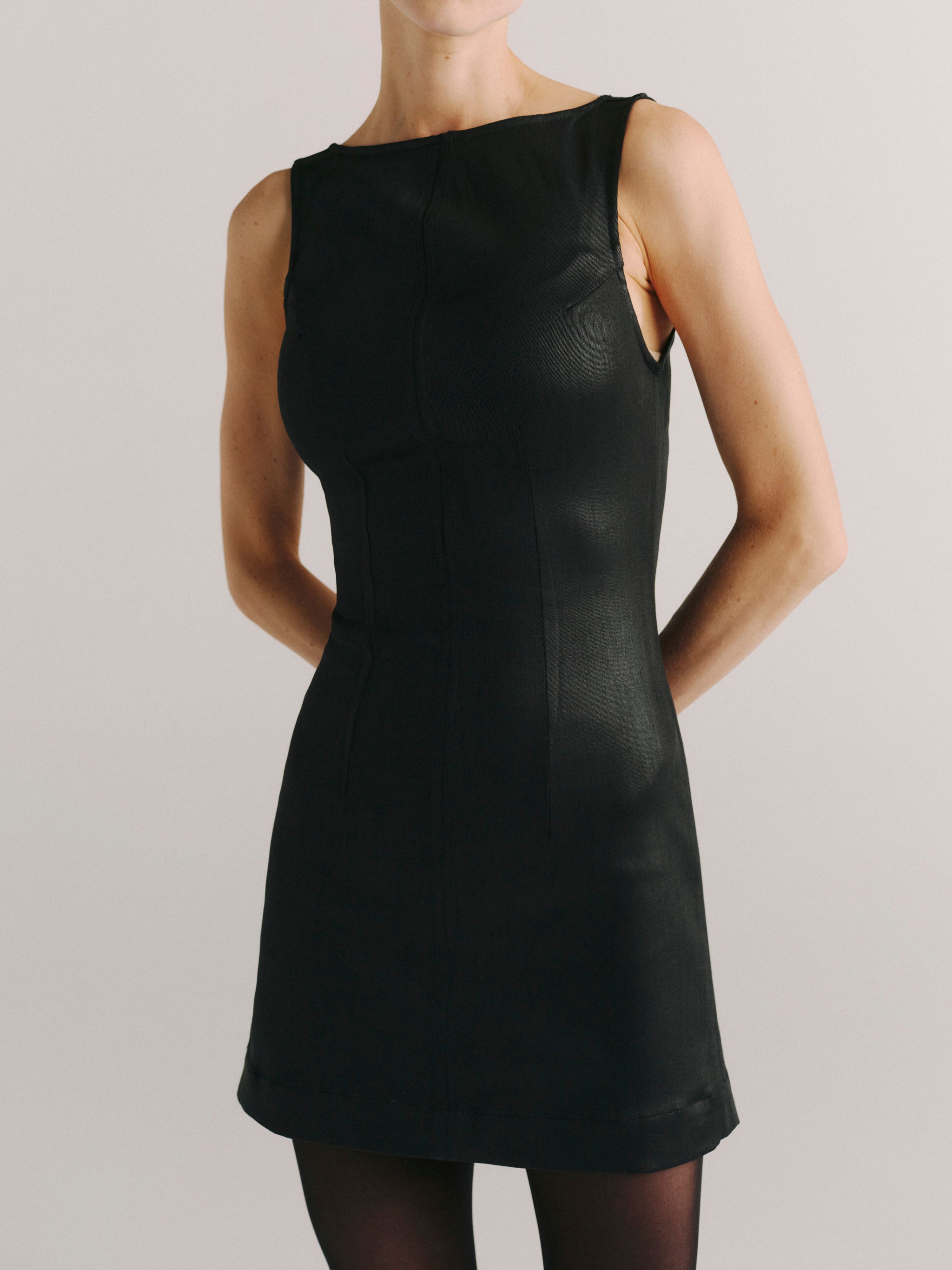 DL1961 women's Esme boat neck Instasculpt denim mini dress in 'Black Hawk Coated', close-up of the boat neckline and coated seams.