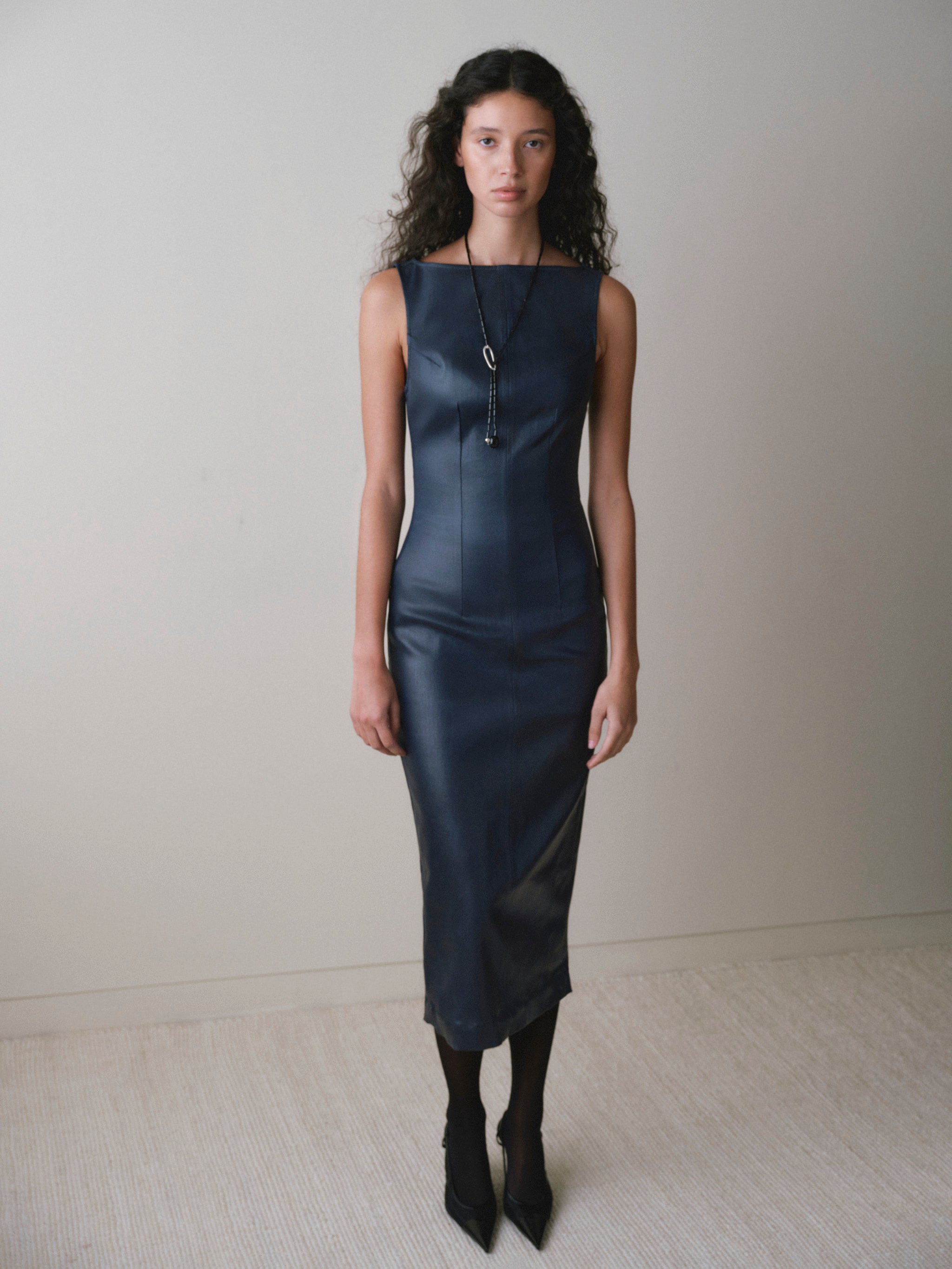 DL1961 women's Esme boat neck Instasculpt denim dress in 'Navy Blue Coated', full-length front view with sheer black tights.