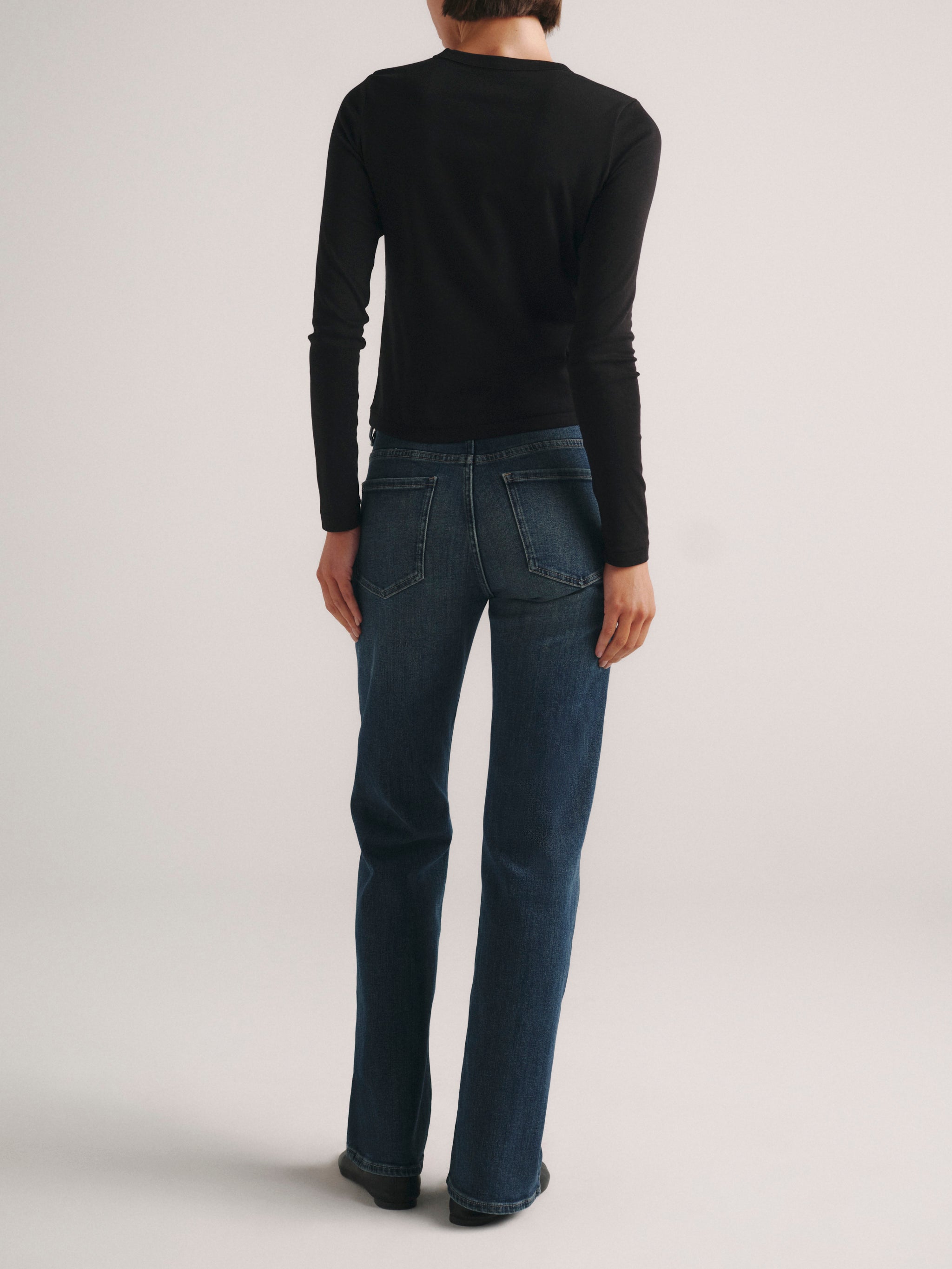 DL1961 Shrunken Tee long-sleeve in black with blue jeans, full-length back view.