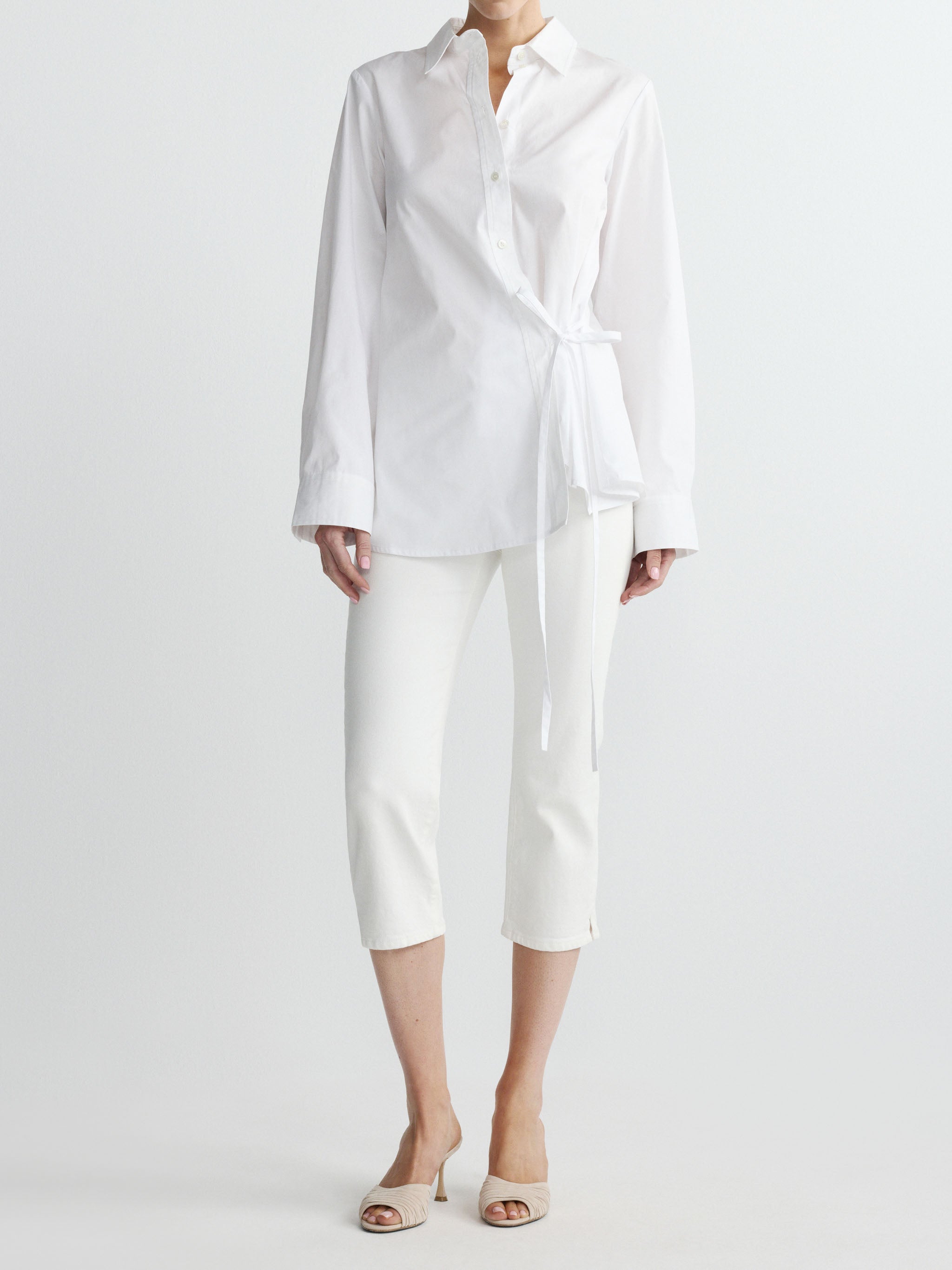 Person wearing a white shirt and pants on a plain background