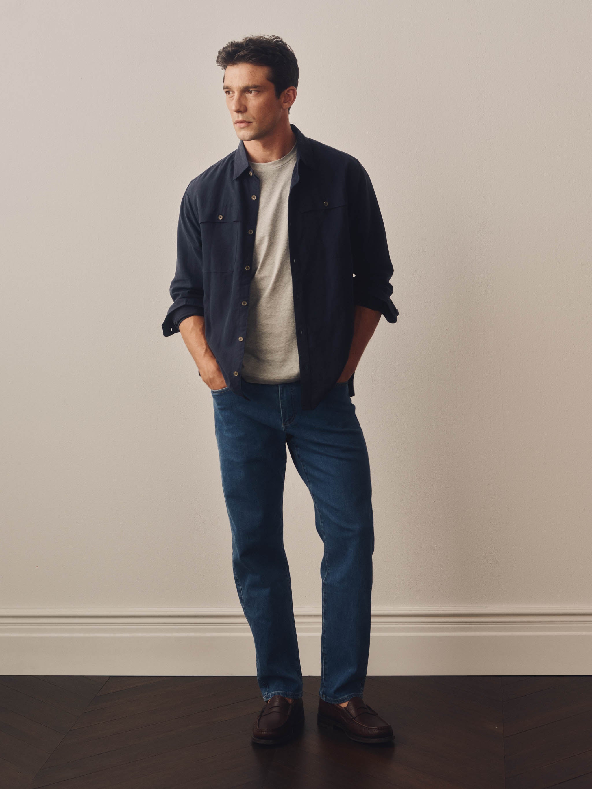 Man wearing a navy blue shirt with button details on a white background