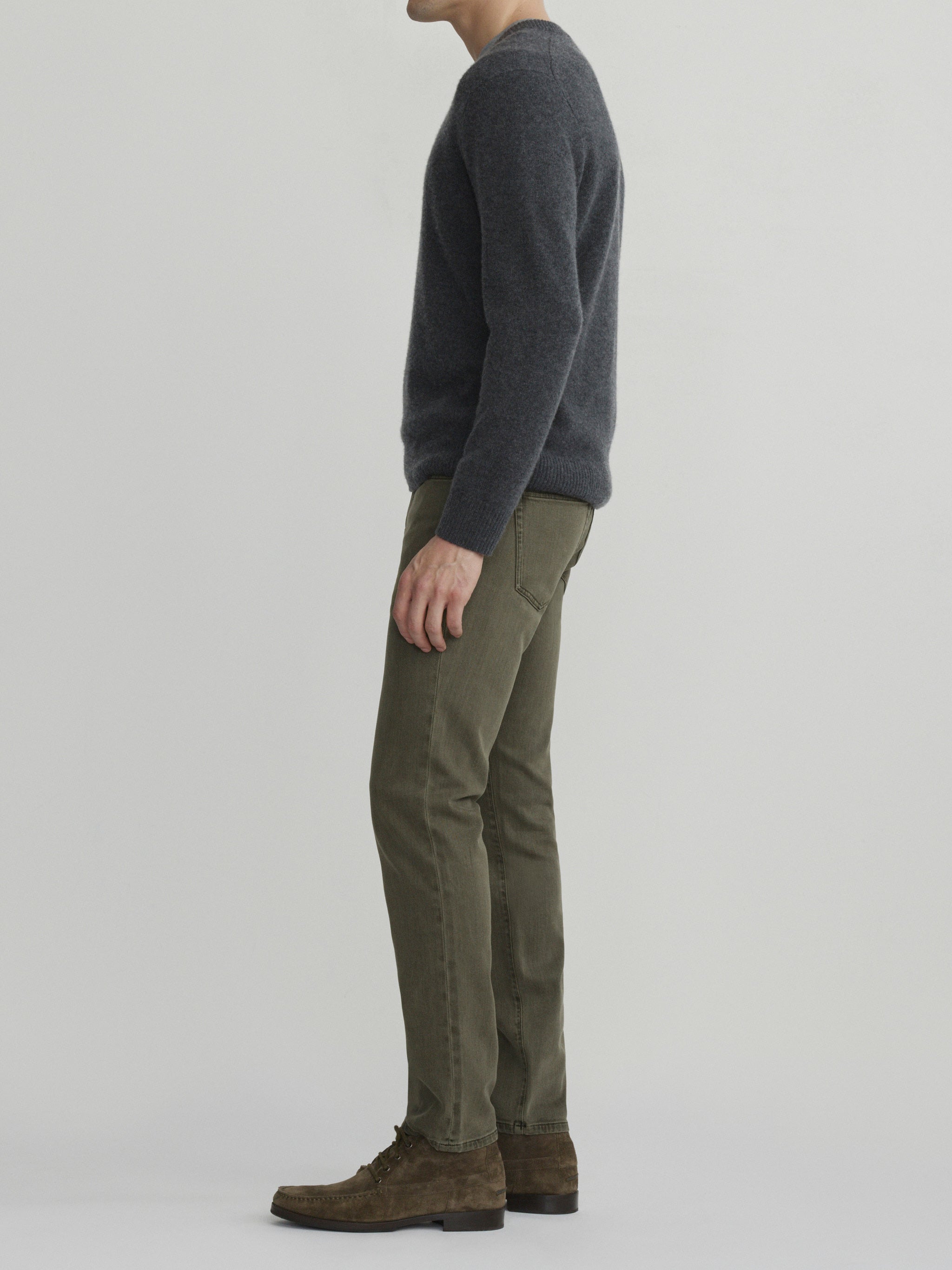 DL1961 men's Nick Slim jeans in olive green 'Outpost', full-length side profile with charcoal sweater