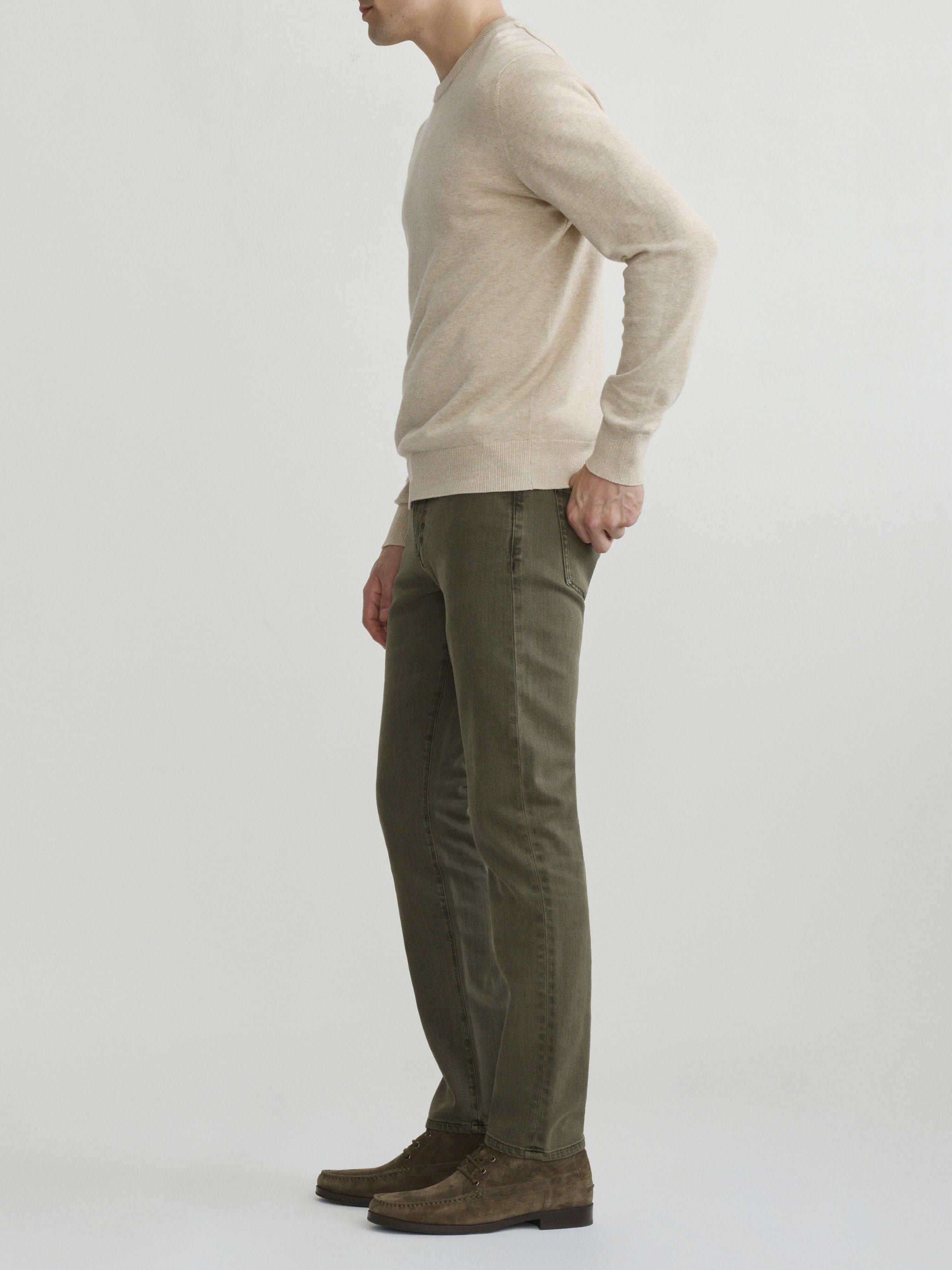 DL1961 men's Russell Slim Straight jeans in olive green 'Outpost', full-length side profile with oatmeal sweater.